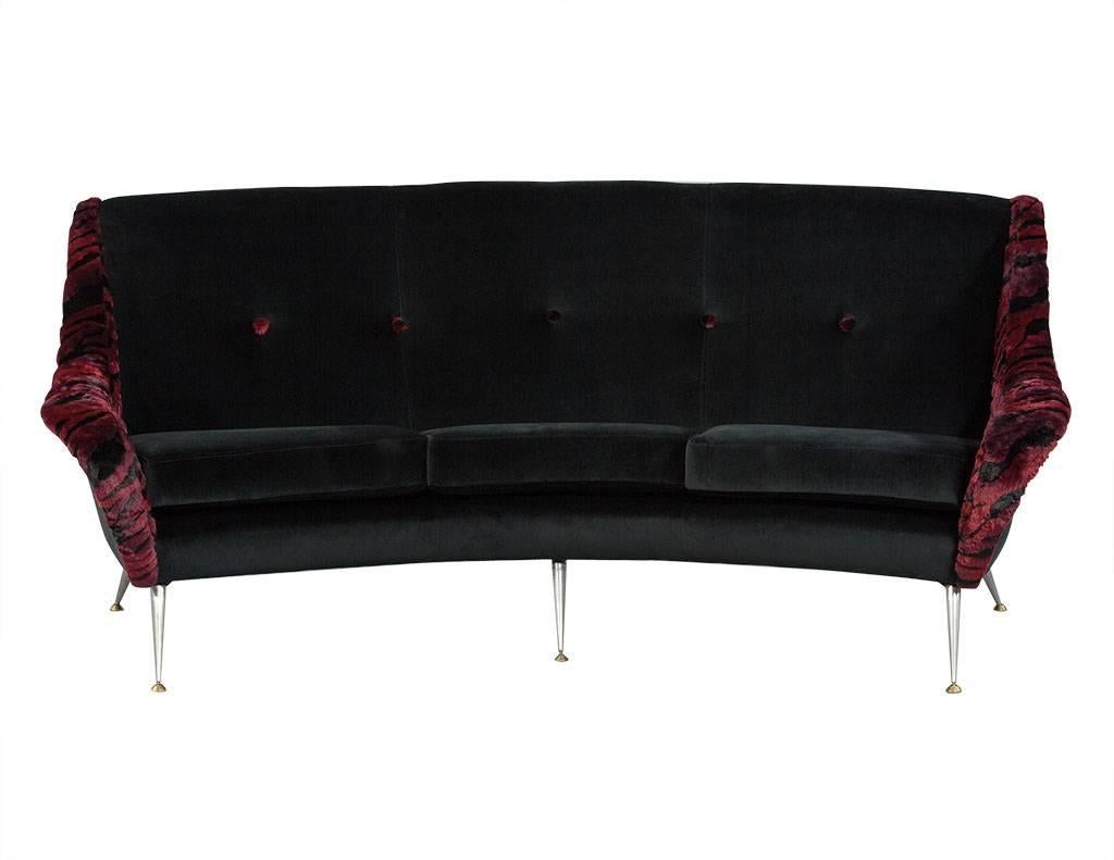 This Italian modern settee is designed by Gio Ponti. The seat is wrapped in a rich, black velvet with a tufted backrest, five buttons, and armrests that are accented with a tiger red and black velvet with matching buttons. The piece is truly a work