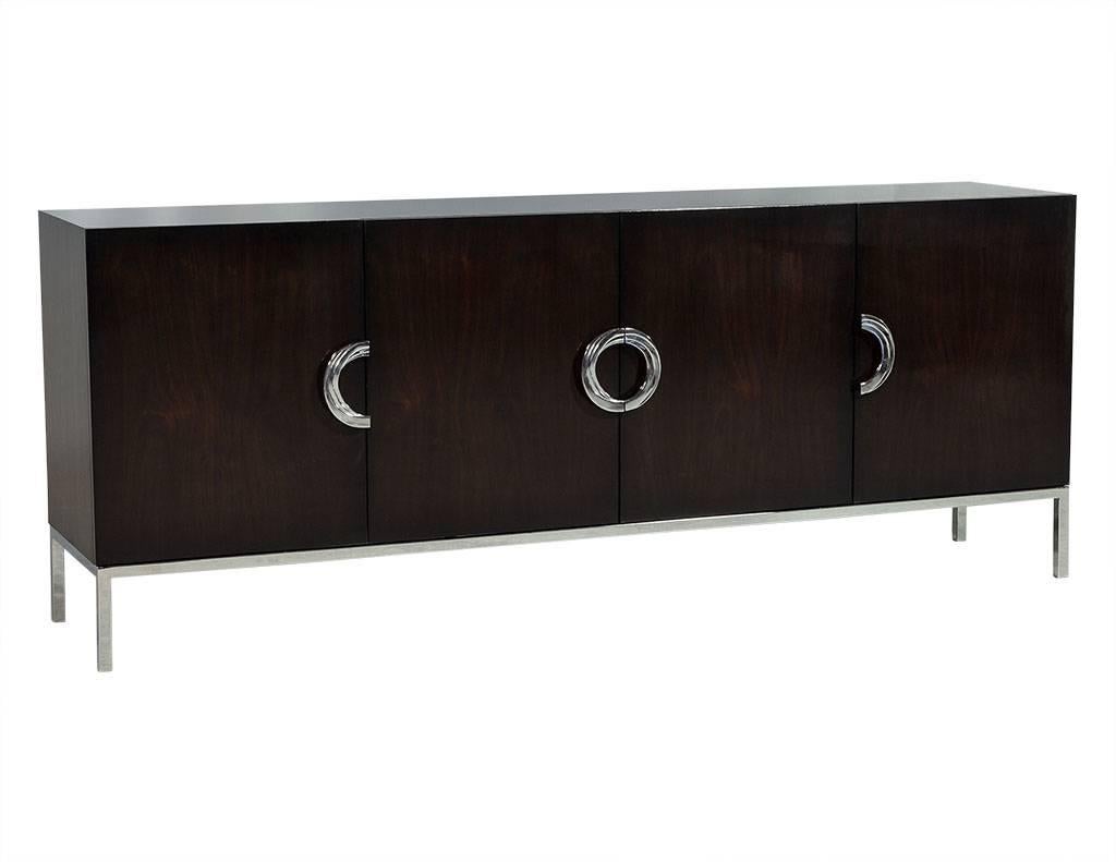 Carrocel custom, stunning rift cut walnut sideboard hand polished in a rich brown custom finish. This cabinet has four doors with polished stainless steel semicircle hardware. The richly finished walnut drawers have under-mount self closing slides