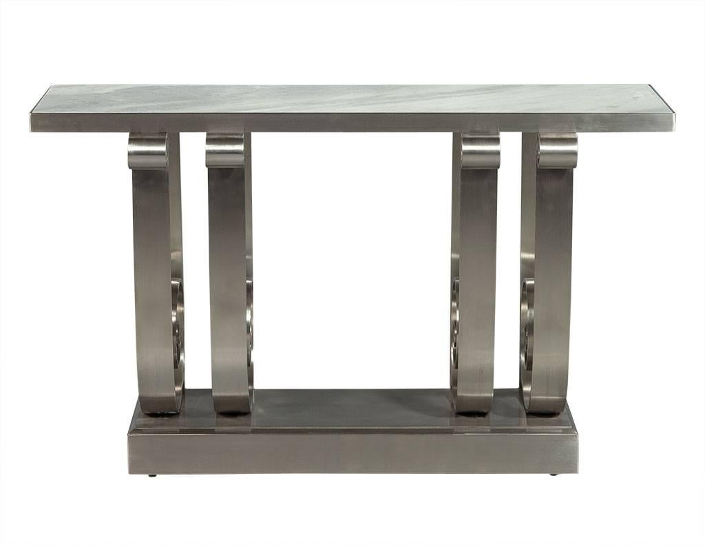 This console table is an absolute stunner. It has a white and grey marble top sitting upon scroll design stainless steel supports. There are four wide straight supports at the back as well, connected to the thick base and four curved front supports.