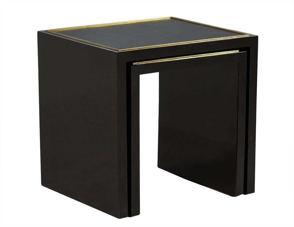 This modern nesting table set is Art Deco inspired, circa 1930s. They are crafted out of black polished mahogany with a black leather inset frame and polished brass inlay trim. A gorgeous set, perfect for a luxe home.

Measures: Smaller: H: 17.75”
