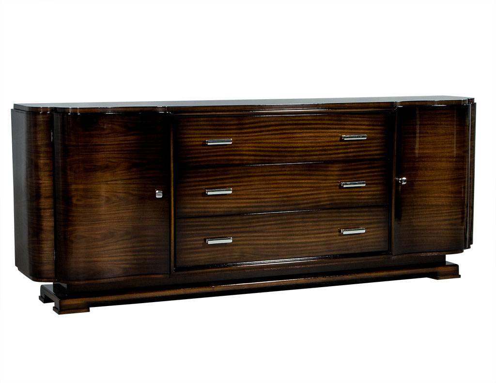 This made to order, Art Deco style buffet is crafted out of solid walnut. It has three large drawers in the middle with two curved doors on the ends with three shelves inside. A functional and beautiful piece, perfect for a Classic home. This piece