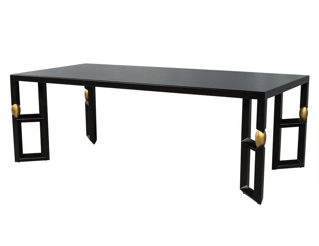 Modern ebonized dining table. Featuring a dark brown finish with gold leaf accents. Four double column legs are angled 45 degrees toward centre giving this piece a modern flare. An excellent option for a sophisticated space.