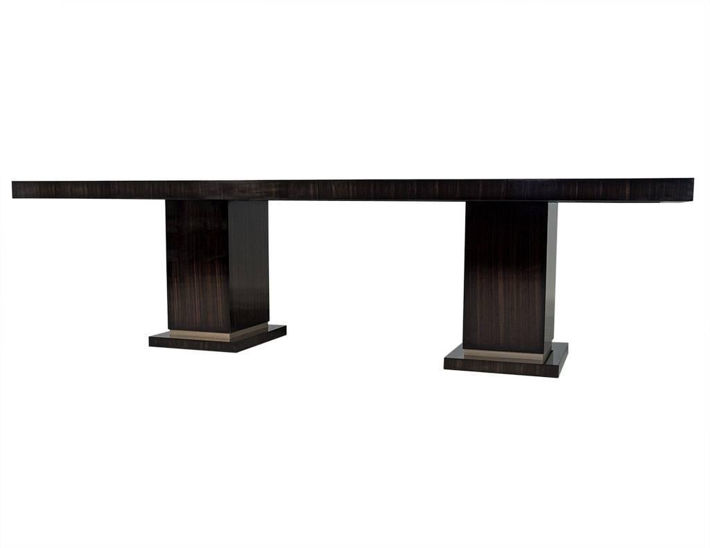This made to order dining table is part of the Carrocel Custom collection. Crafted out of Macassar, the table sits atop two rectangular pedestal bases fitted with metal detail. A perfect fit for a modern home!