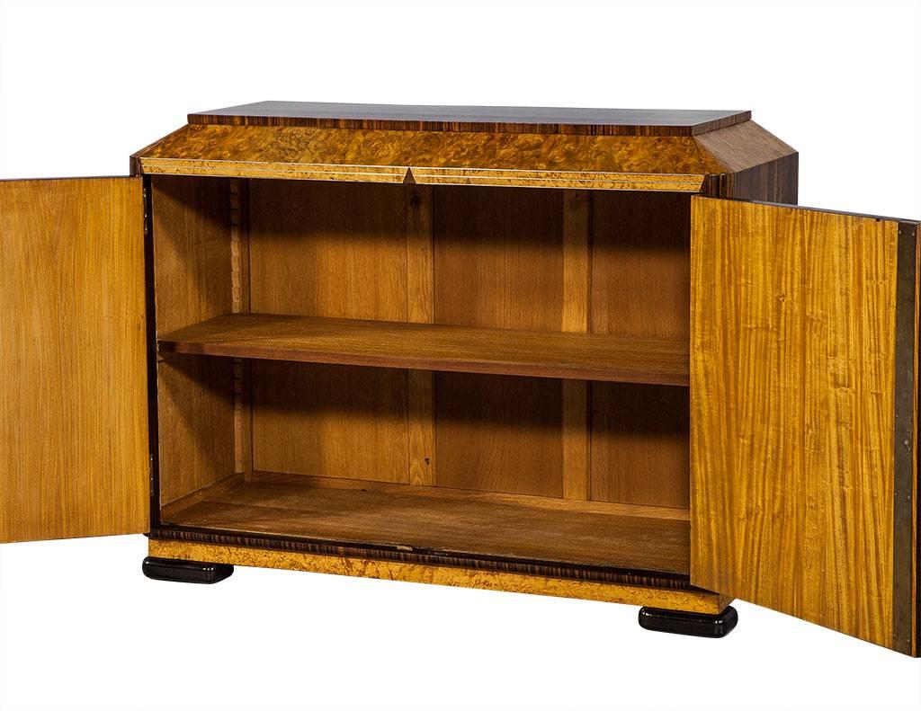 This Art Deco server cabinet is unique and stylish.  Hailing from France, it boasts amazingly detailed exotic veneers cut into geometric diamond patterns of book-matched burl walnut, Macassar, ebony, and birds eye with a fine metal inlay detail.  A