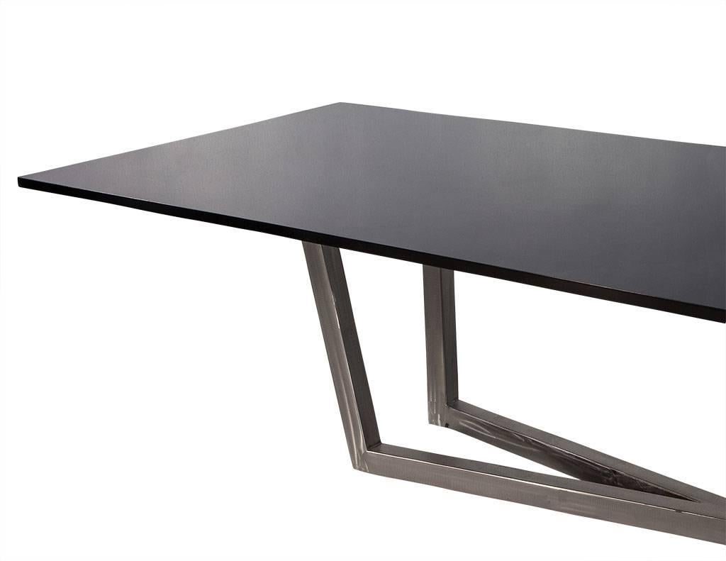 This sleek and modern dining table is part of the Carrocel custom collection. It is composed of a black lacquer top supported by a brushed steel X-shaped base. With its stunning contemporary design, this table truly stands out and can be ordered in