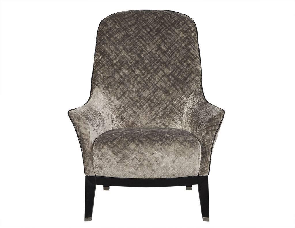 Gorgeous high back lounge chair. This lounge chair is simply luxurious. Curved armrests, braided leather piping on the edges, and a black wood base sitting atop angled legs with silver feet tips. Newly reupholstered, this chair is a true lesson in