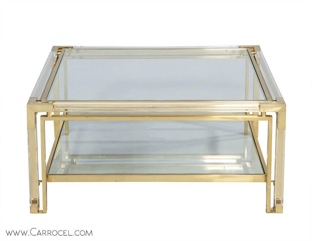 Linear, sleek and stunning, this cocktail table illustrates the allure of Italian design by Romeo Rega. The structure seamlessly combines a double frame of Lucite and polished brass with an inset glass center top. A relic of the past, a piece of