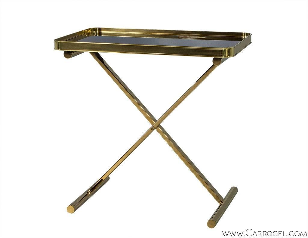 A modern take on a classic design, this Cross Brace Tray Table emulates the style we’ve come to expect of Ralph Lauren’s furniture collection. A polished brass frame holding an inset top of smoked glass forms the table’s sleek lines. The