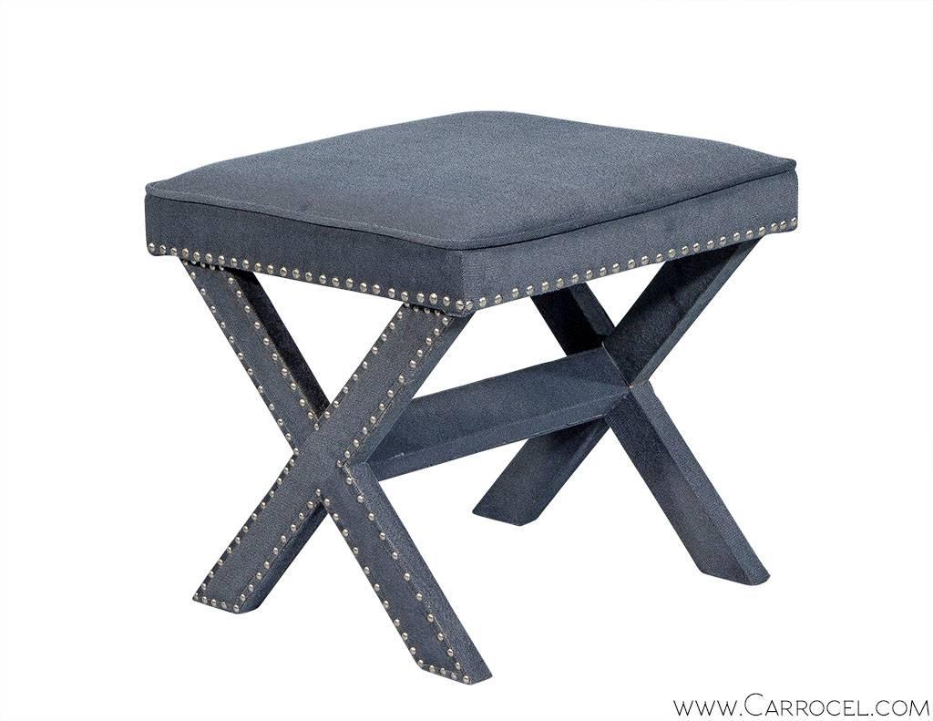 A perfect deuce, this pair of ottomans are great accent pieces to add to your space. Fully upholstered with a soft grey-blue velvet they offer texture with a subtle pop of colour. The tops are edged with space polished silver nails that also