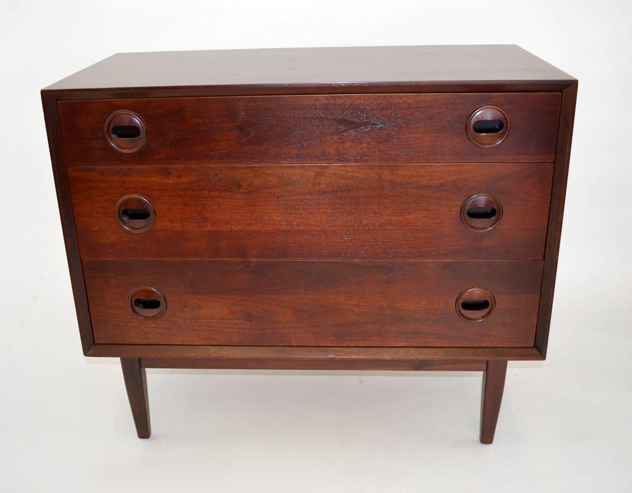 Pair of handsome three-drawer Danish design teak chests of drawers or commodes, circa 1960s. Sleek, modern lines with seldom-seen sculpted round handles. Wood bases. Perfect as a pair or separated as nightstands.