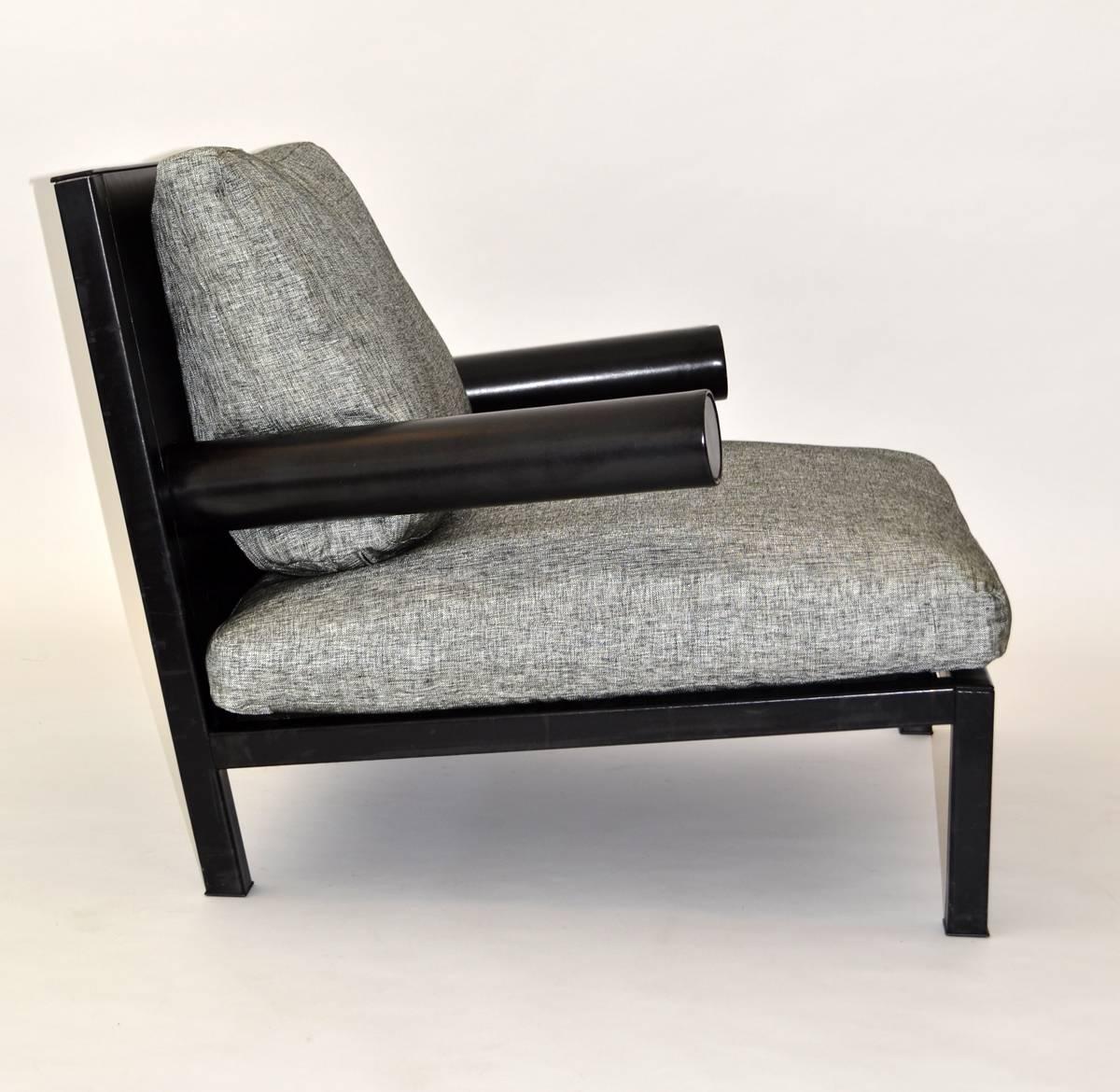 Oversized armchair wrapped in black leather over sturdy steel frame with three upholstered loose cushions. Signed.