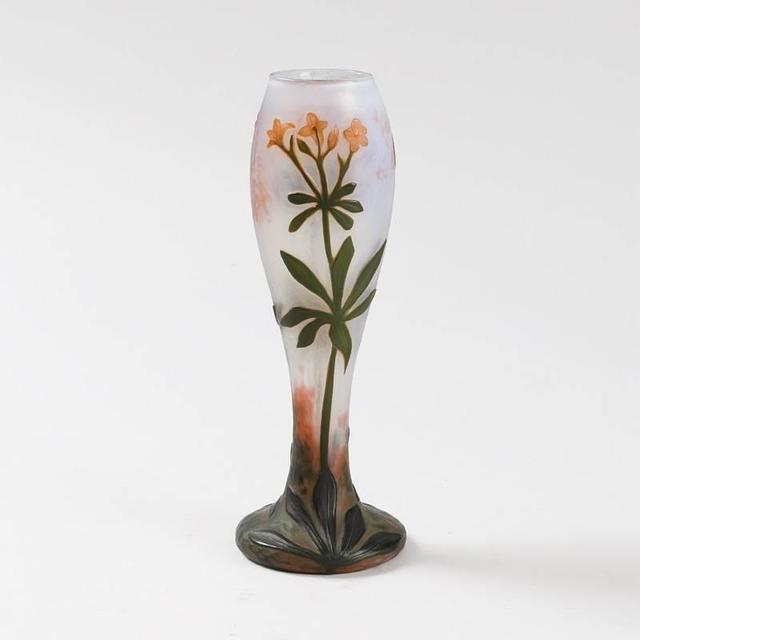 A French wheel carved cameo glass vase by Daum. The creation of this vase combined the technique of hammering for the foot and wheel carving for the flower decorations. The background is made of opalescent glass, with green and orange flowers