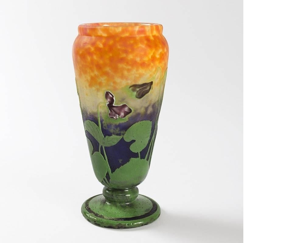 A French cameo glass vase by Daum. This beautiful vase, moving from blue to yellow and orange, imitates the sun setting on water, represented water lilies. 

(MG #17414)

  