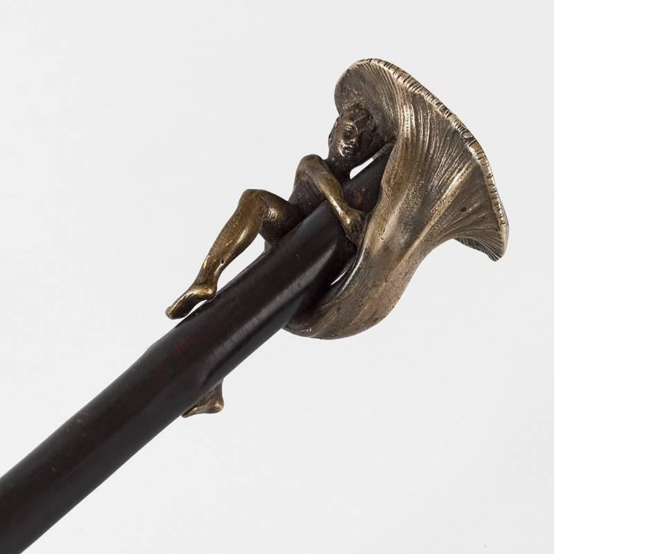 A Pommeau de Canne, 'Child under a Mushroom' bronze and ebony walking cane by François Rupert Carabin. The gilt bronze cane handle is a mushroom cap. A young boy clings to the cane, sheltered under the mushroom. 

A similar cane is pictured in: Art