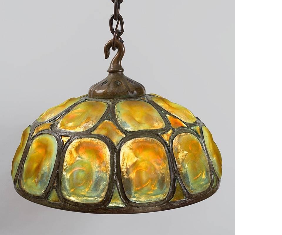 A Tiffany Studios New York "Turtleback Tile" chandelier.  In many ways the aesthetic opposite of his flowered lamps, these hanging lights exude a simple, strong, masculine energy. Rather than being built from many small pieces of glass in