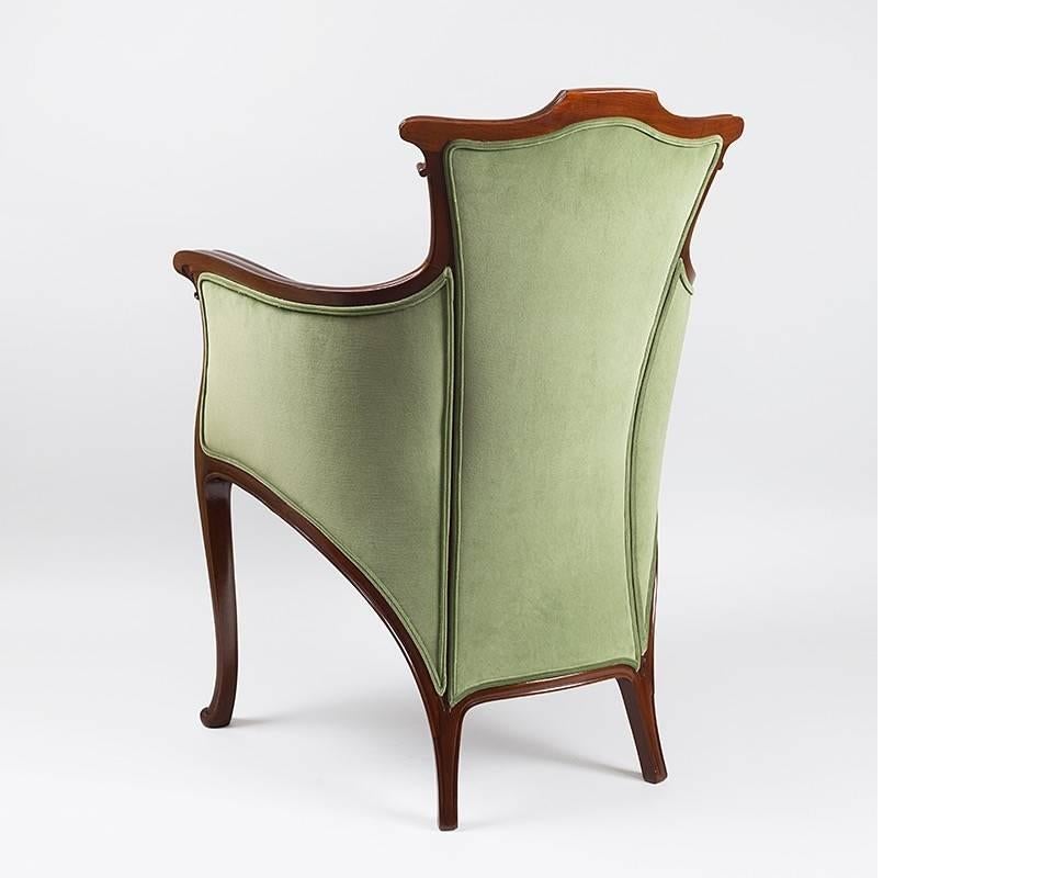 A French Art Nouveau armchair, by Edouard Colonna, in carved mahogany with green upholstery.  Circa 1900.   A similar chair is pictured in The Paris Salons, 1895-1910, Volume III: Furniture, by Alastair Duncan, Antique Collectors’ Club, Publishers,