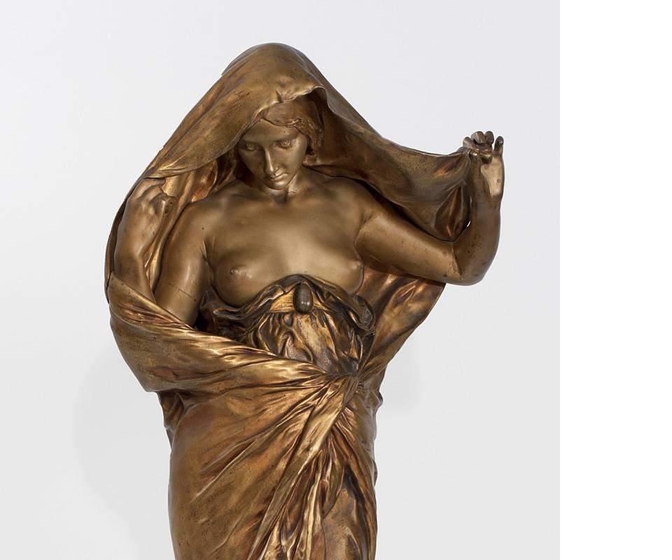 A French Art Nouveau gilt and patinated bronze figural sculpture by Ernest Barrias, titled “La Nature se devoilant a La Science (Nature Revealing Herself Before Science). The use of polychrome patinas and the exaggeration of the central scarab