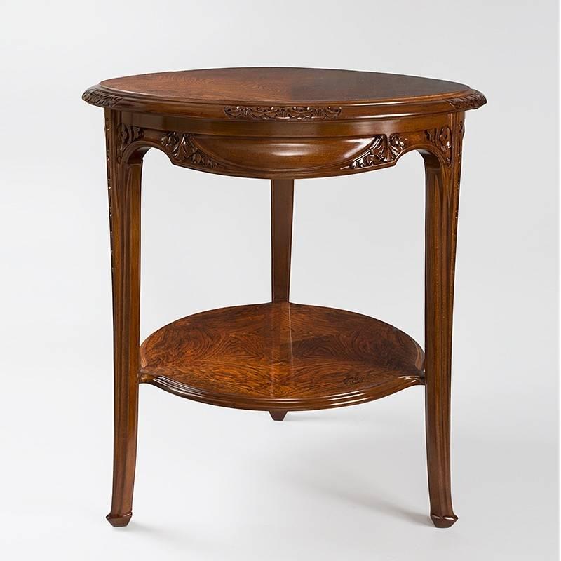 A French Art Nouveau table by Louis Majorelle. This two-tiered mahogany table is carved with vegetal forms and flowers. The three legs are also carved, and the top is composed of beautifully grained wood, circa 1900s.

Signed, ''Majorelle Nancy''.