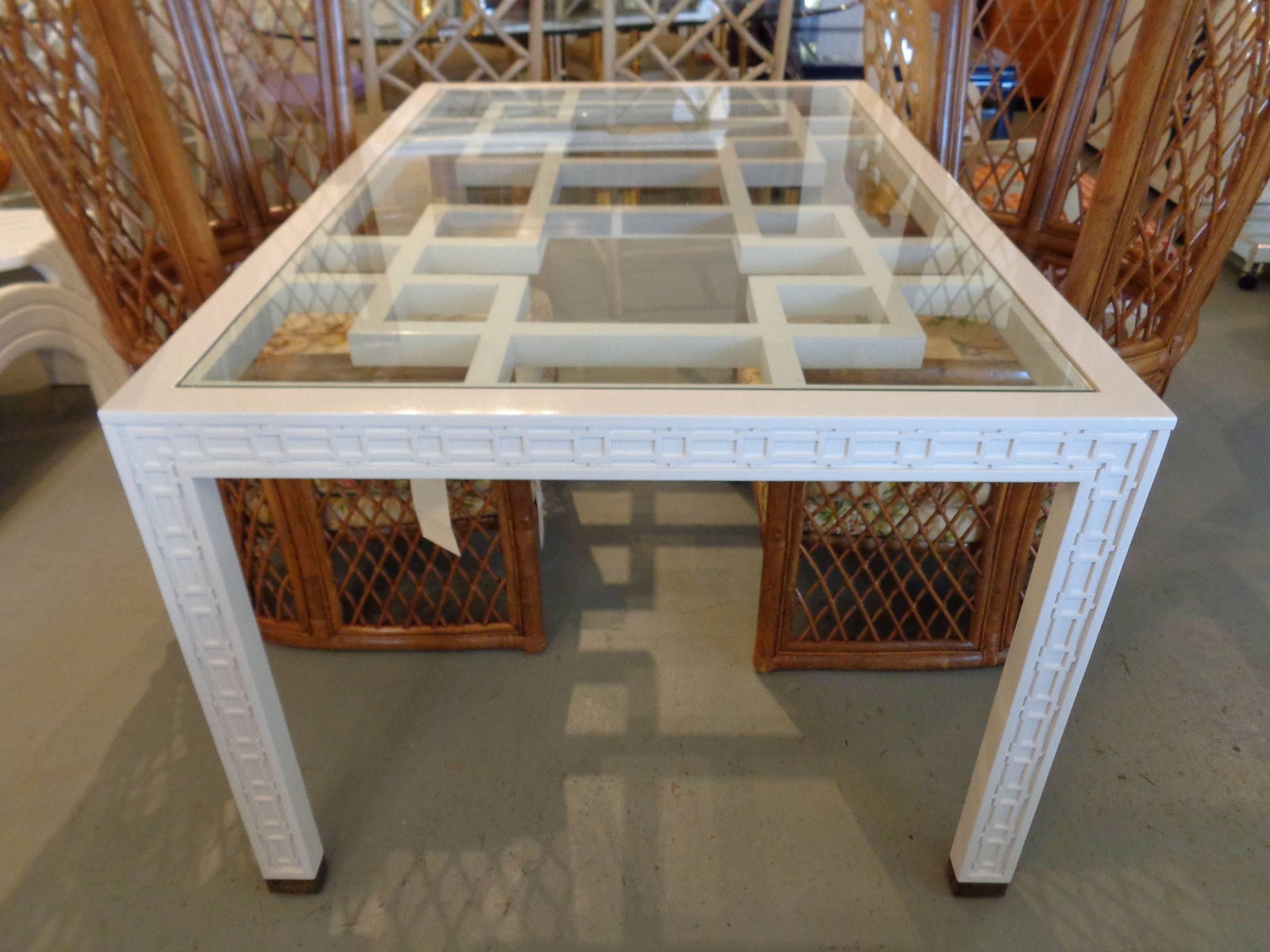 Fretwork dining table with inset glass top in nice as found vintage condition. There are minor imperfections to the newly lacquered finish. Patina to brass caps.