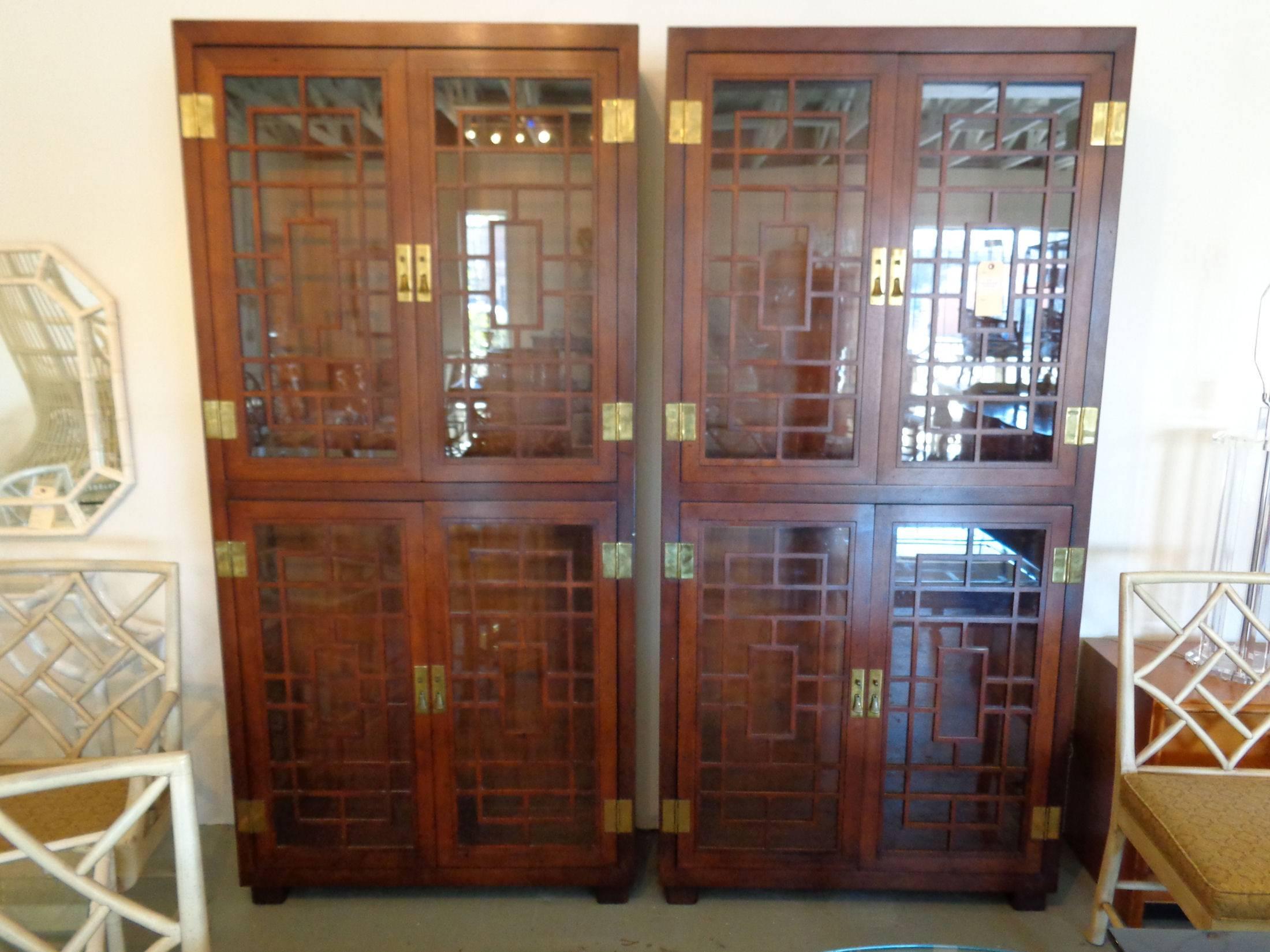 Pair of fretwork cabinets by Henredon in nice as found vintage condition. There are scuffs and scrapes to the as found finish and patina to the hardware. Cabinets have glass shelves and original interior lighting.