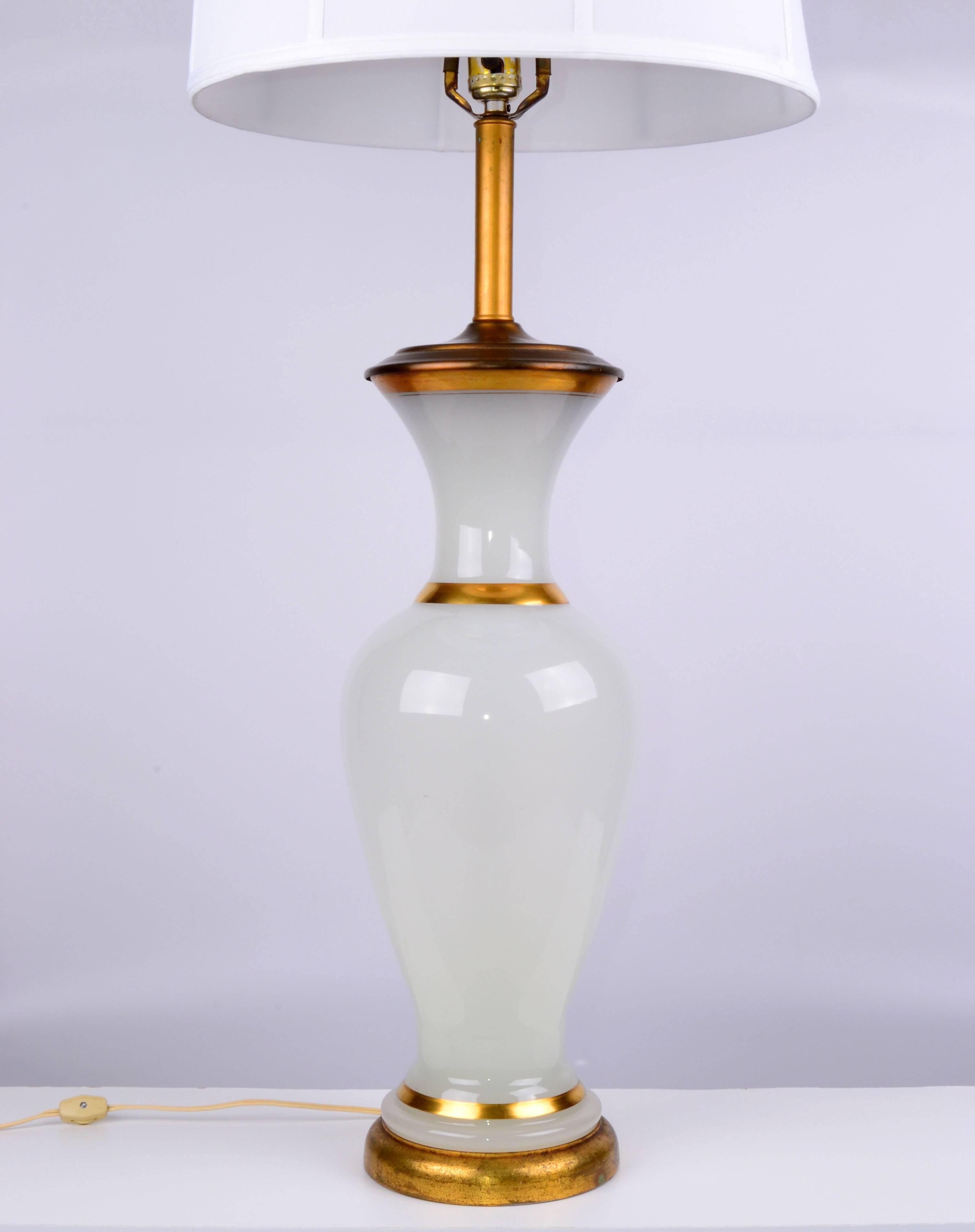 1950s opal glass and brass table lamp on a wood base with gilt finish.
Harp and finial included.
Wired for the U.S. and has a three-way function; uses a 50-100-150W bulb.
Height to top of socket: 30.75 inches H. Shade not included.