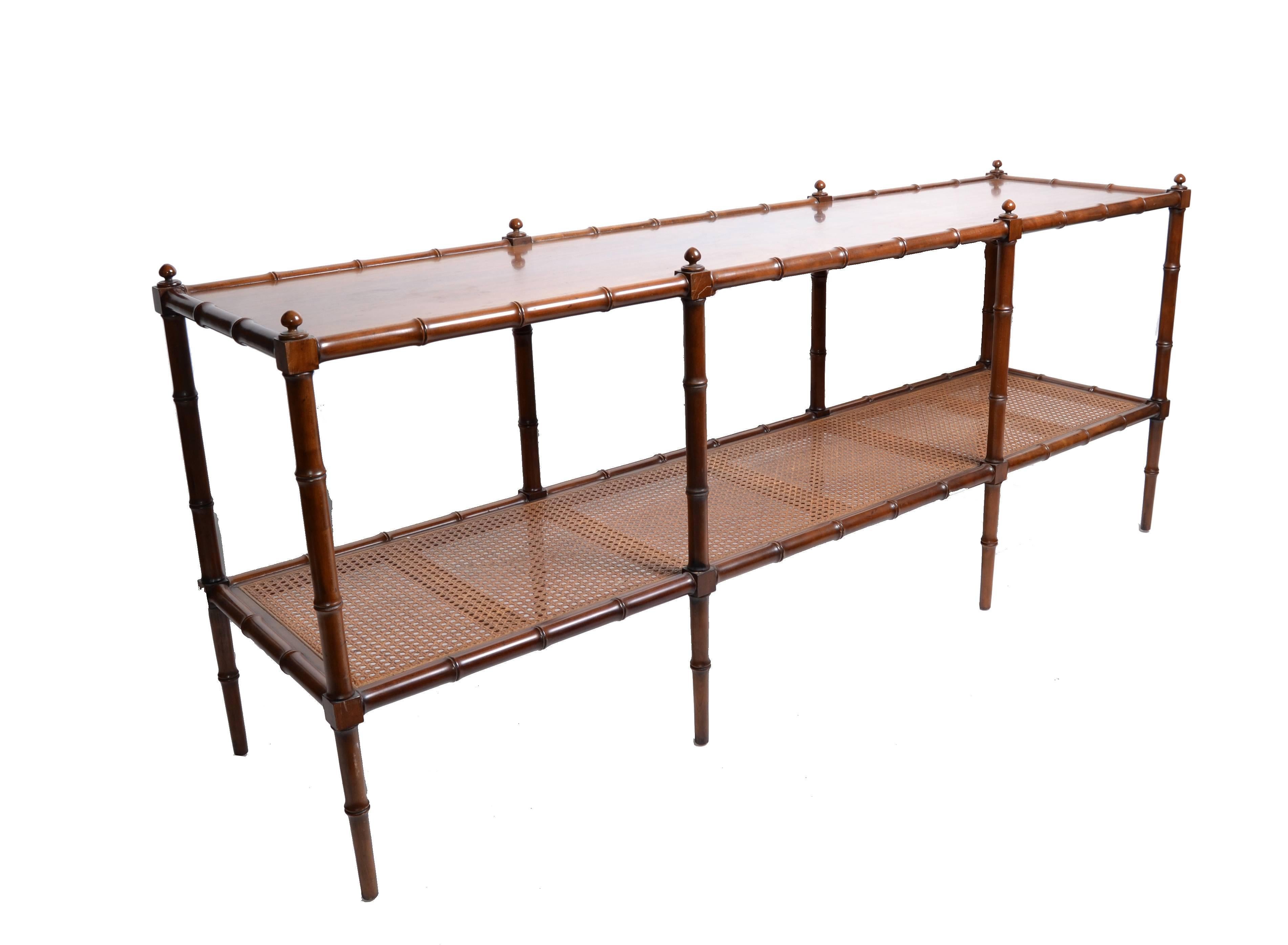 Stunning console table, sofa table or shelf with eight faux bamboo legs crowned with round finials. The walnut top has an incredible grain pattern and the lower cane shelf is great for storage.
The original baker furniture tag is attached