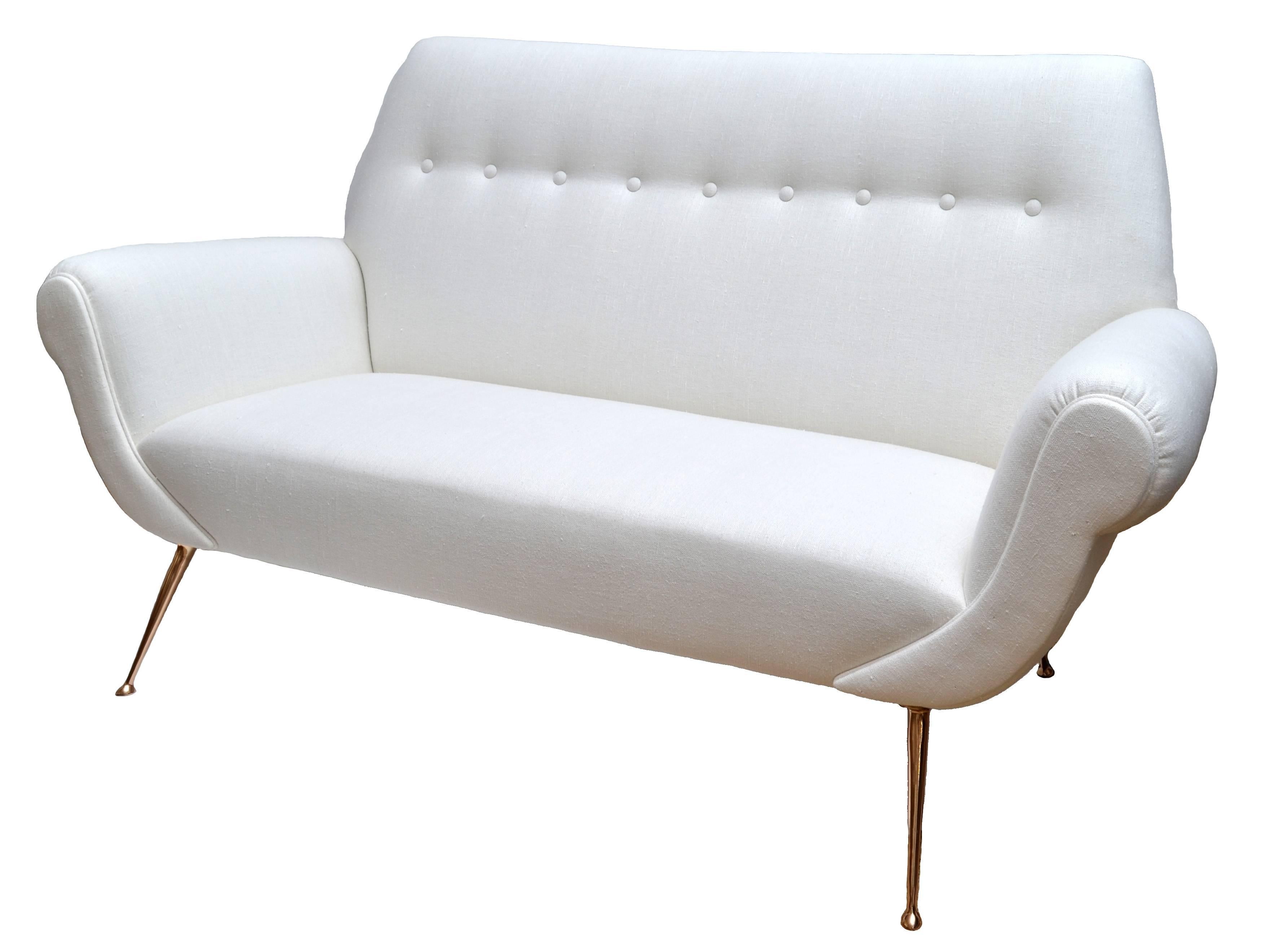 This 1950 Italian sofa was designed by Gigi Radice and manufactured by Minotti.
New white upholstery, square tuxedo cut backrest, with button tufted back, tight seat, rolled arms and self-welting, with solid brass legs.
This sofa is ready to put