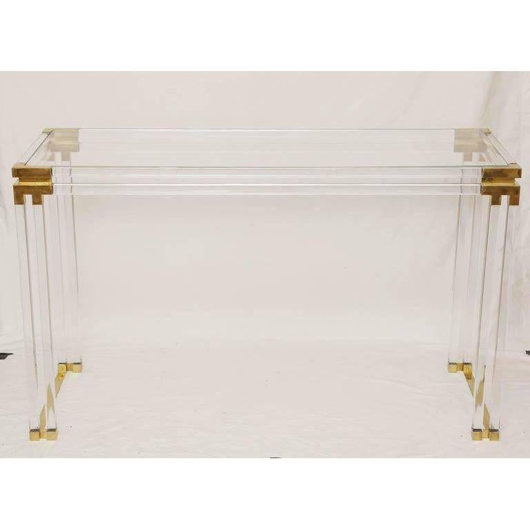 A simply gorgeous Lucite glass console table with brass details attributed to Charles Hollis Jones.
The glass top sits in the frame.