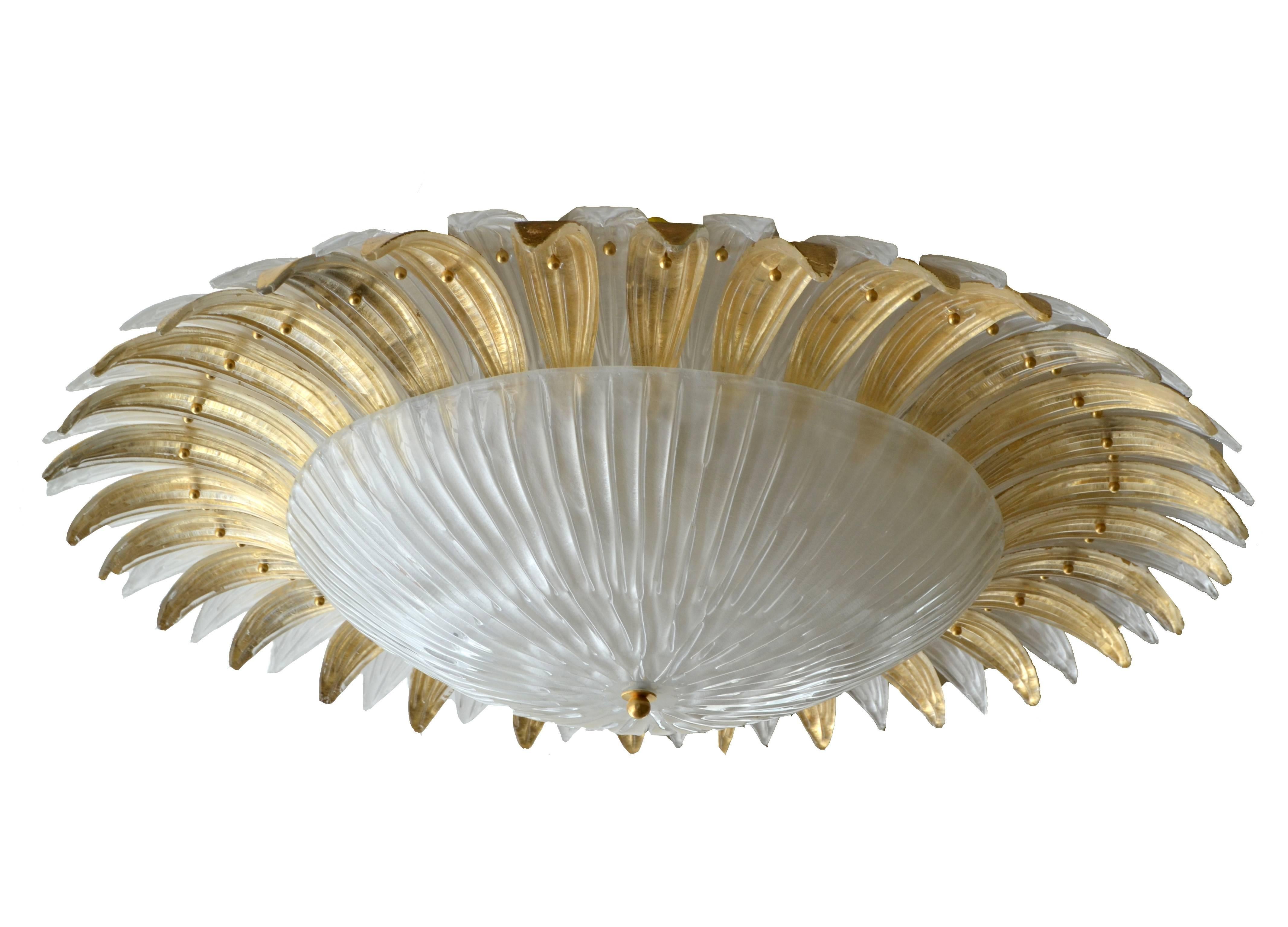 Offered is a stunning palm leaf chandelier in Murano glass from Italy. This chandelier is arranged with gold and clear Murano glass palm leaves, flush mounted to the ceiling. 

Wired for the U.S. and uses six regular light bulbs.

This