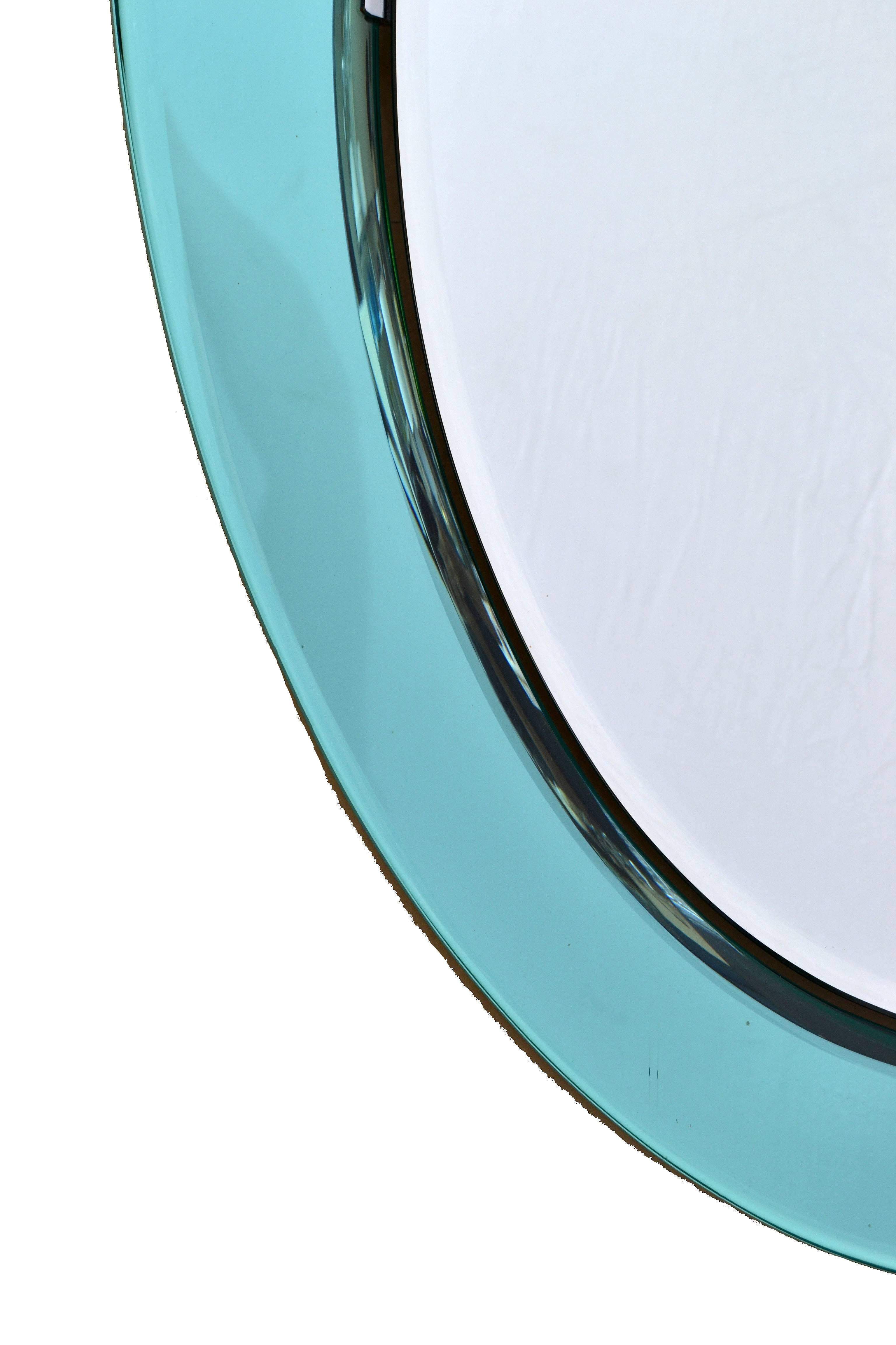 Fontana Arte oval mirror.
Two tone colored mirror glass on a wooden backing.
Overall a Classic design with the flair from Italy.