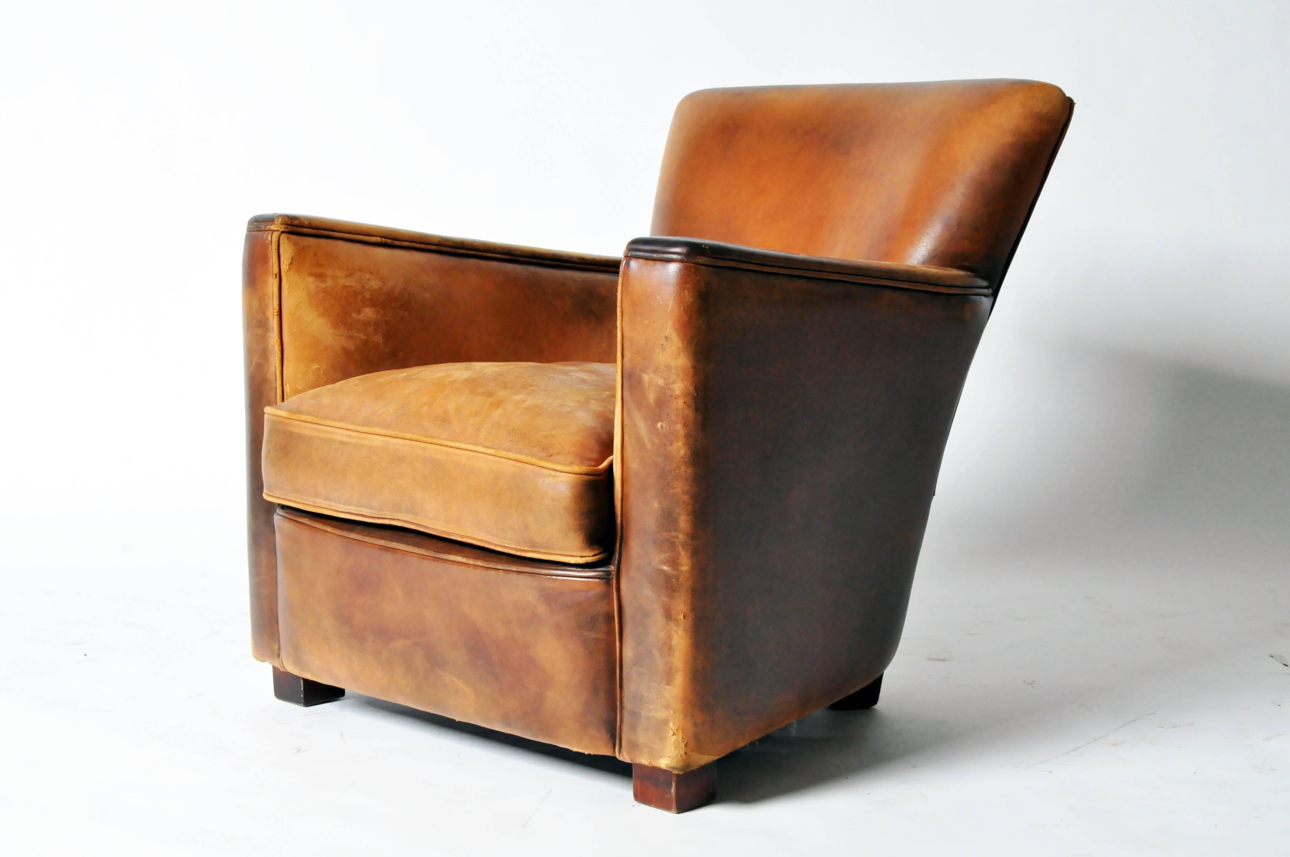 The slightly rounded back and straight track arms emphasize the clean-cut angles of this seat. The antiqued leather upholstery and compact size gives a nod to the classic silhouette it is modeled after.