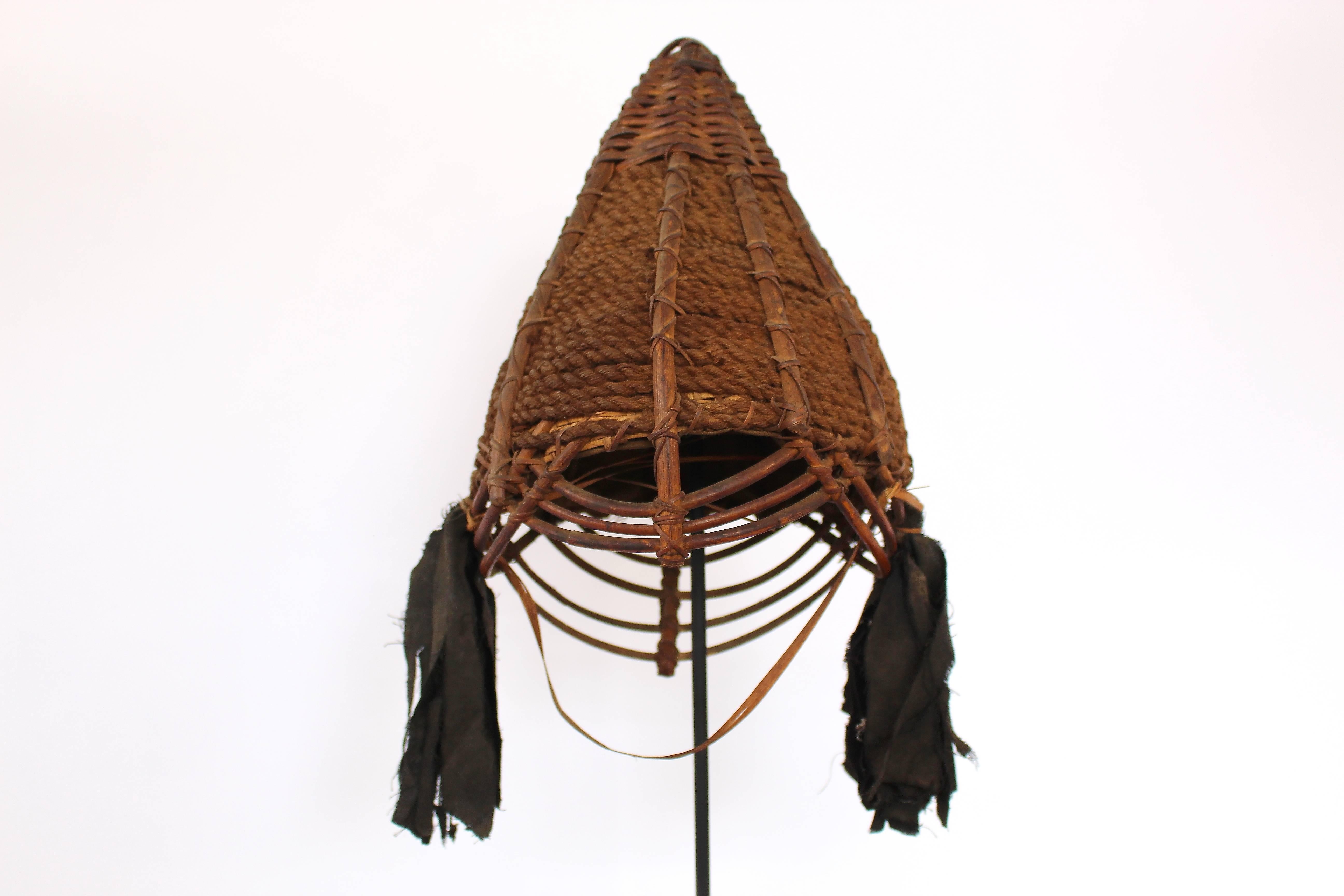 These hats feature wide, open weaving below the brim. Though more decorative than protective, two of them also have cloth tassels on either side.

Like the monumental ornamentation seen on the facades of morungs and dwellings, an individual’s dress