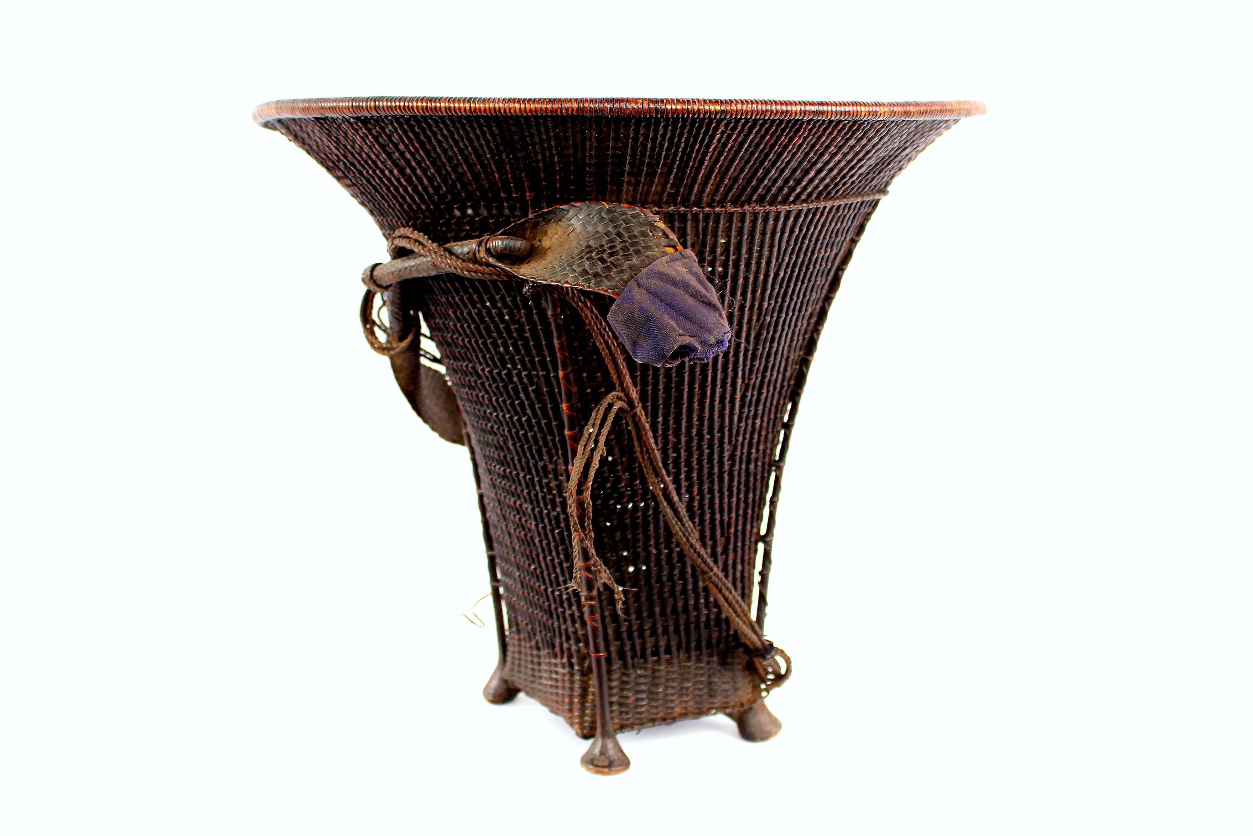 Baskets were used for the transportation and storage of foodstuffs. Wide brim baskets like this, with open weaving were typically used for fishing expeditions. The added strap with loop at the end is for carrying—the strap would be placed around the