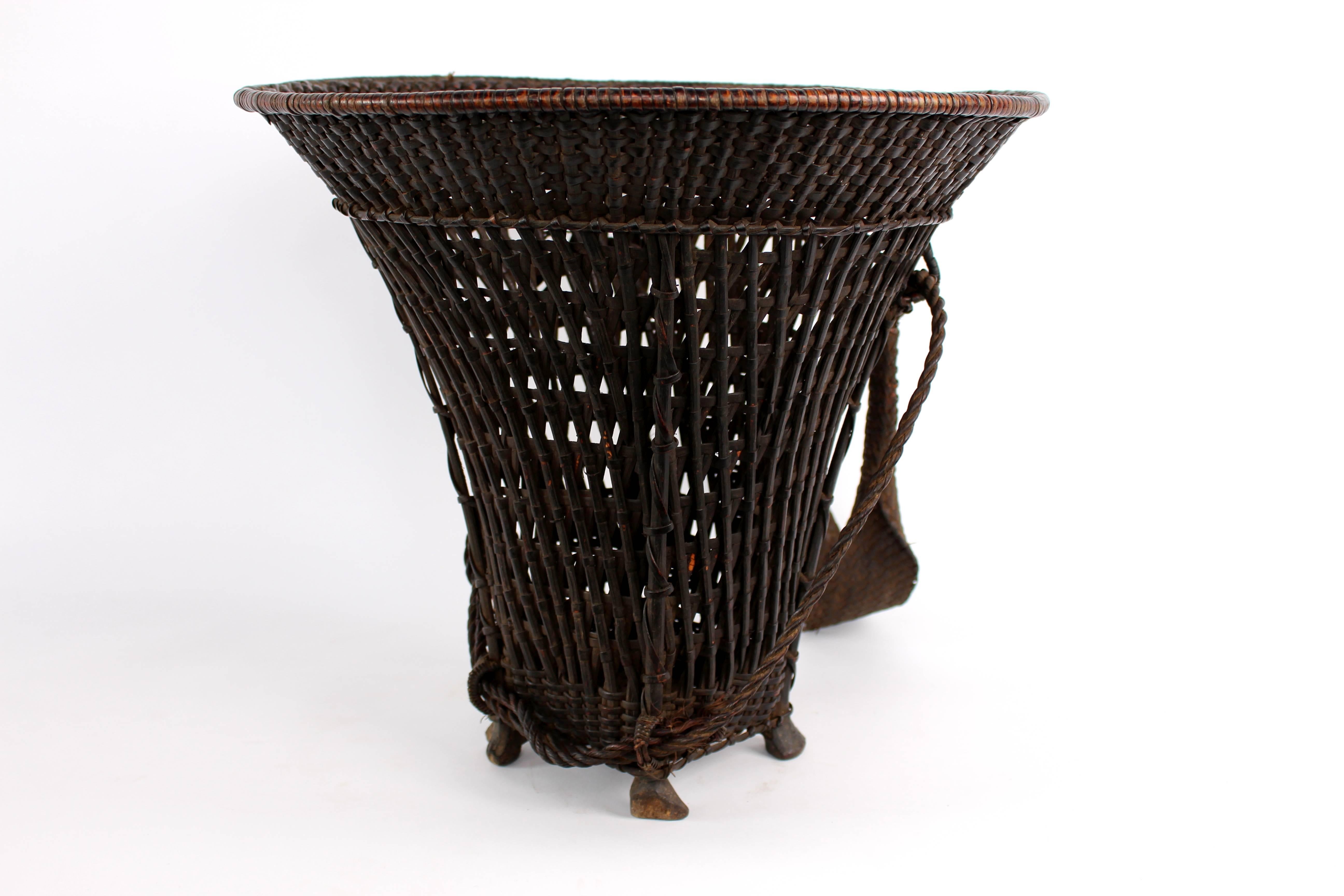 Baskets were used for the transportation and storage of foodstuffs. Wide brim baskets like this, with open weaving were typically used for fishing expeditions. The added strap with loop at the end is for carrying—the strap would be placed around the
