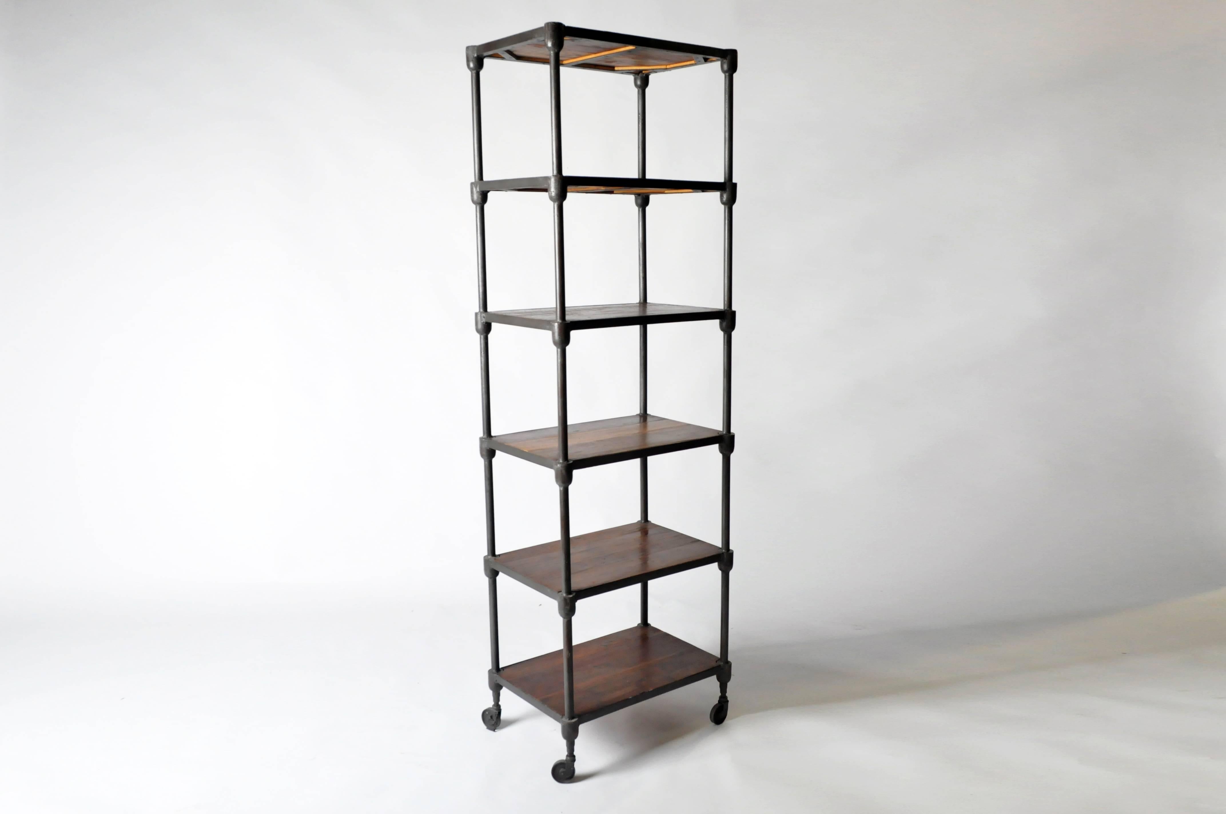 This Industrial shelving piece is from France and is made from metal and wood. It features five shelves for ample storage and display. It also has four wheels on the bottom.