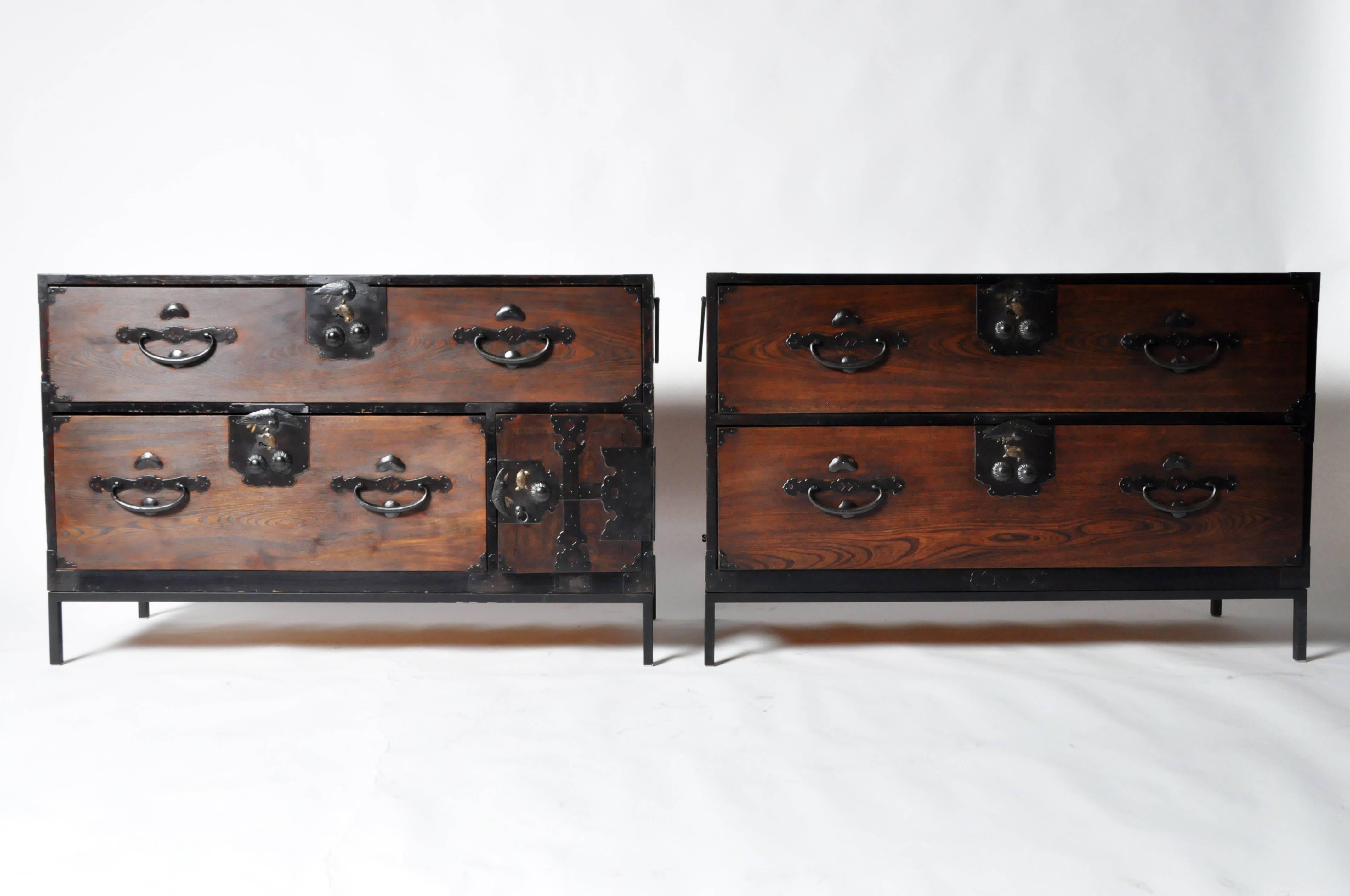 These handsome rectangular chests feature two drawers and detailed lock plates decorated with turtles and birds of prey. One of the pieces is outfitted with a small door covering a secondary compartment that conceals two drawers. Each is raised on a