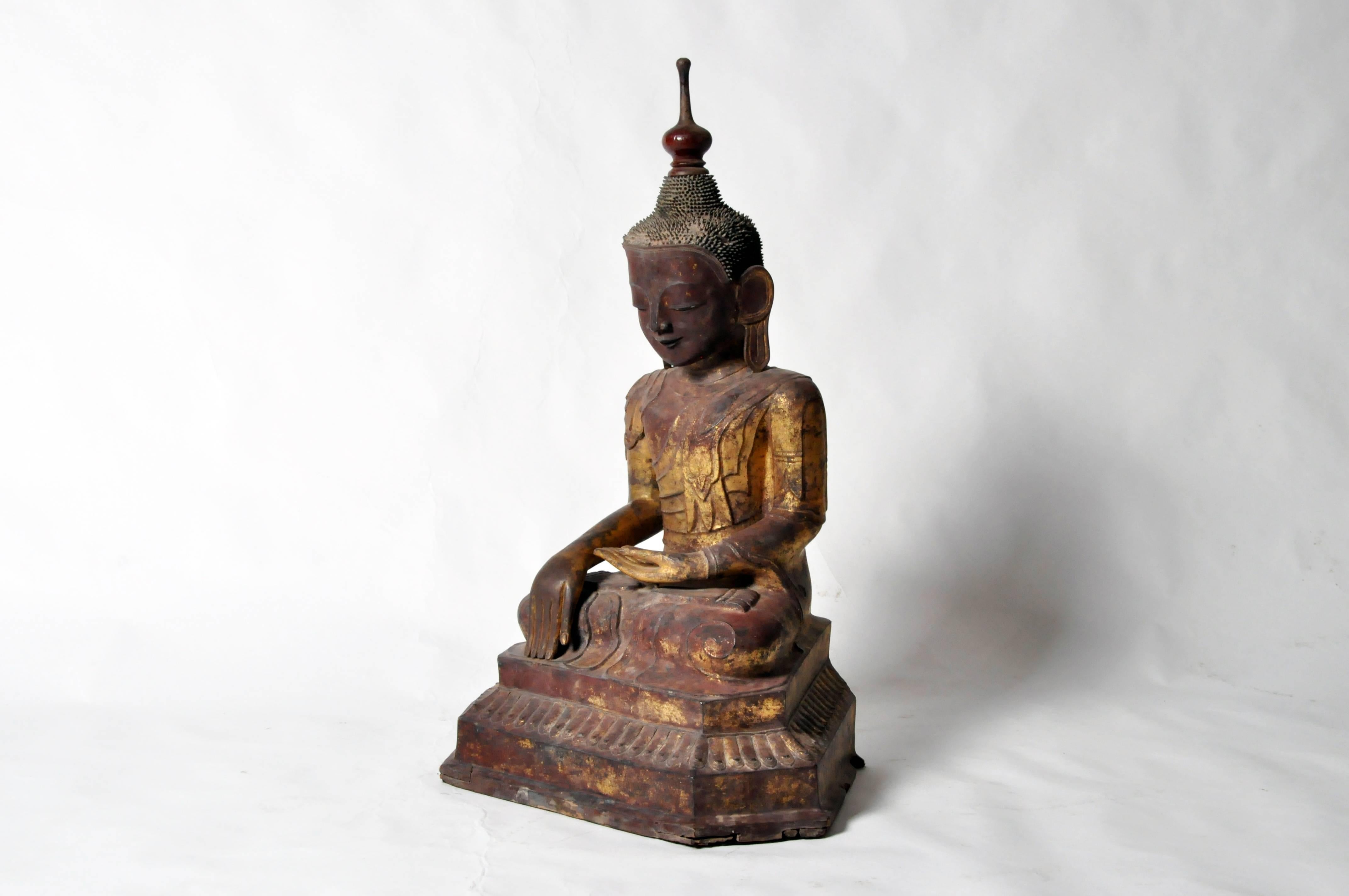 This large and important representation of the historical Buddha, Siddhārtha Gautama, was done in dry lacquer and richly gilt according to Shan-Burmese sculptural traditions. Though territorially part of Burma, the Shan states developed their own