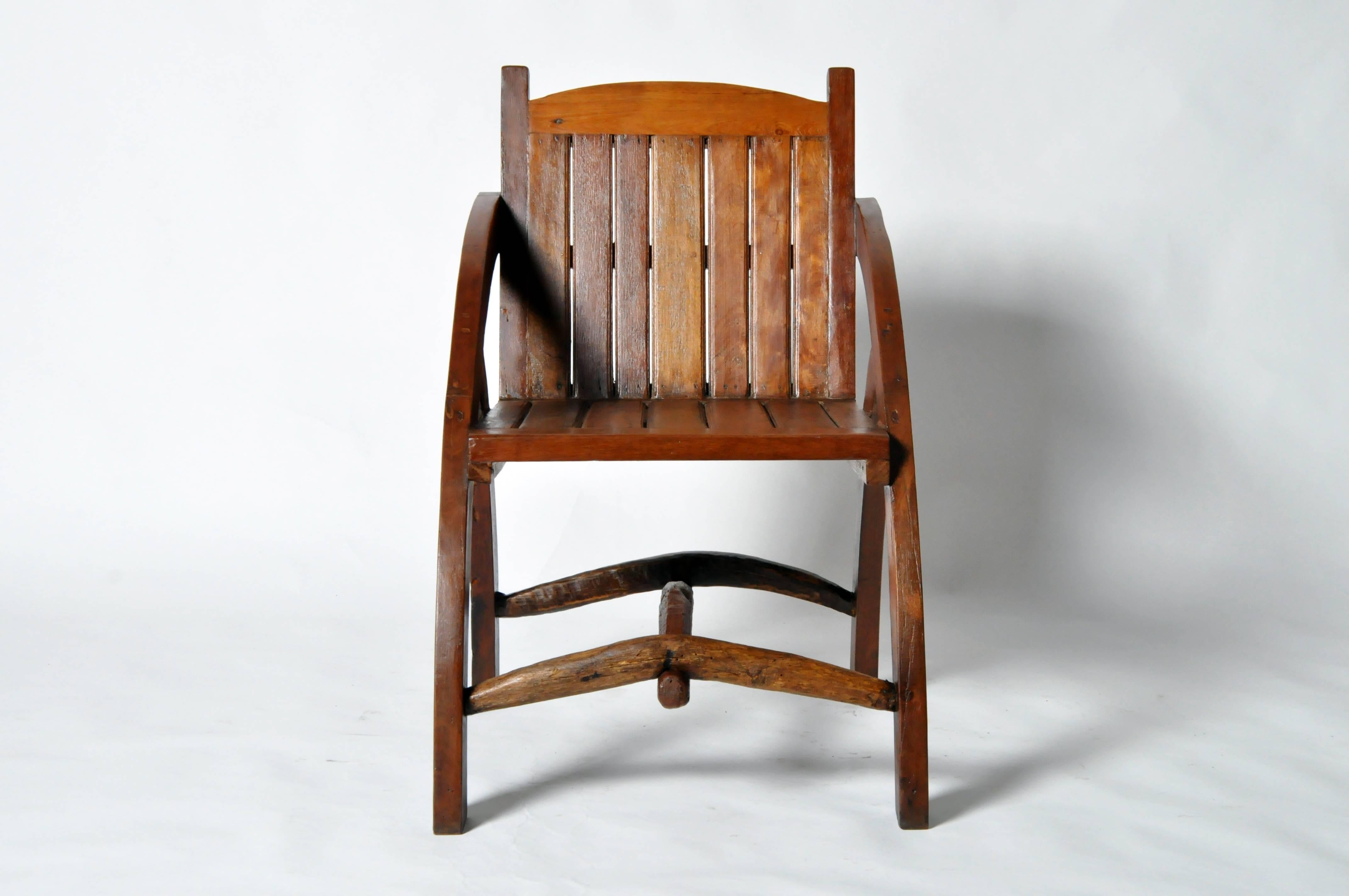 This handsome rustic chair is from Chiangmai, Thailand and was made from reclaimed teakwood. It features curved arms and is comfortable and sturdy.