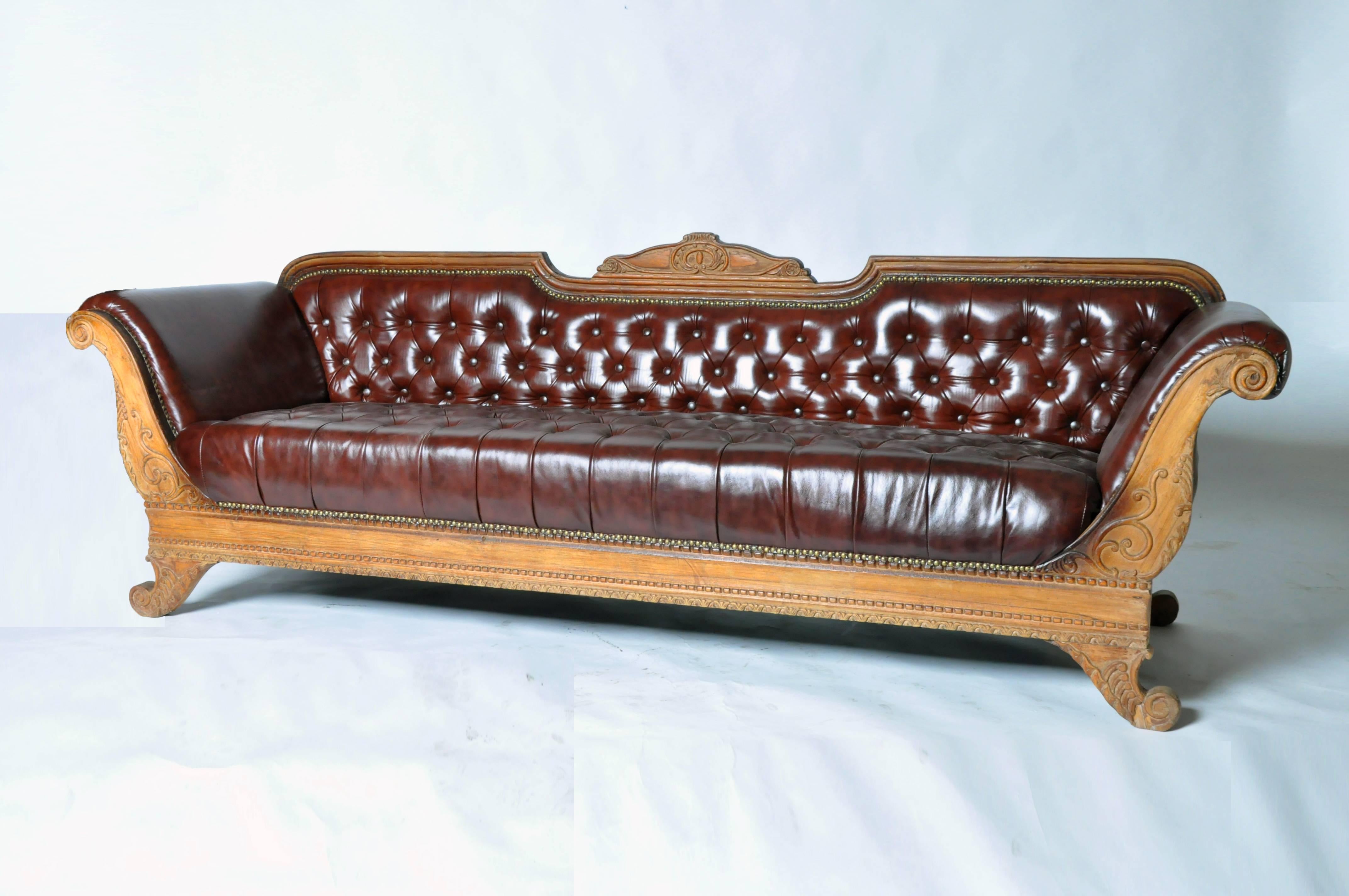 This handsome British Raj style sofa features hand-carved teakwood and is from Gujarat, India.
