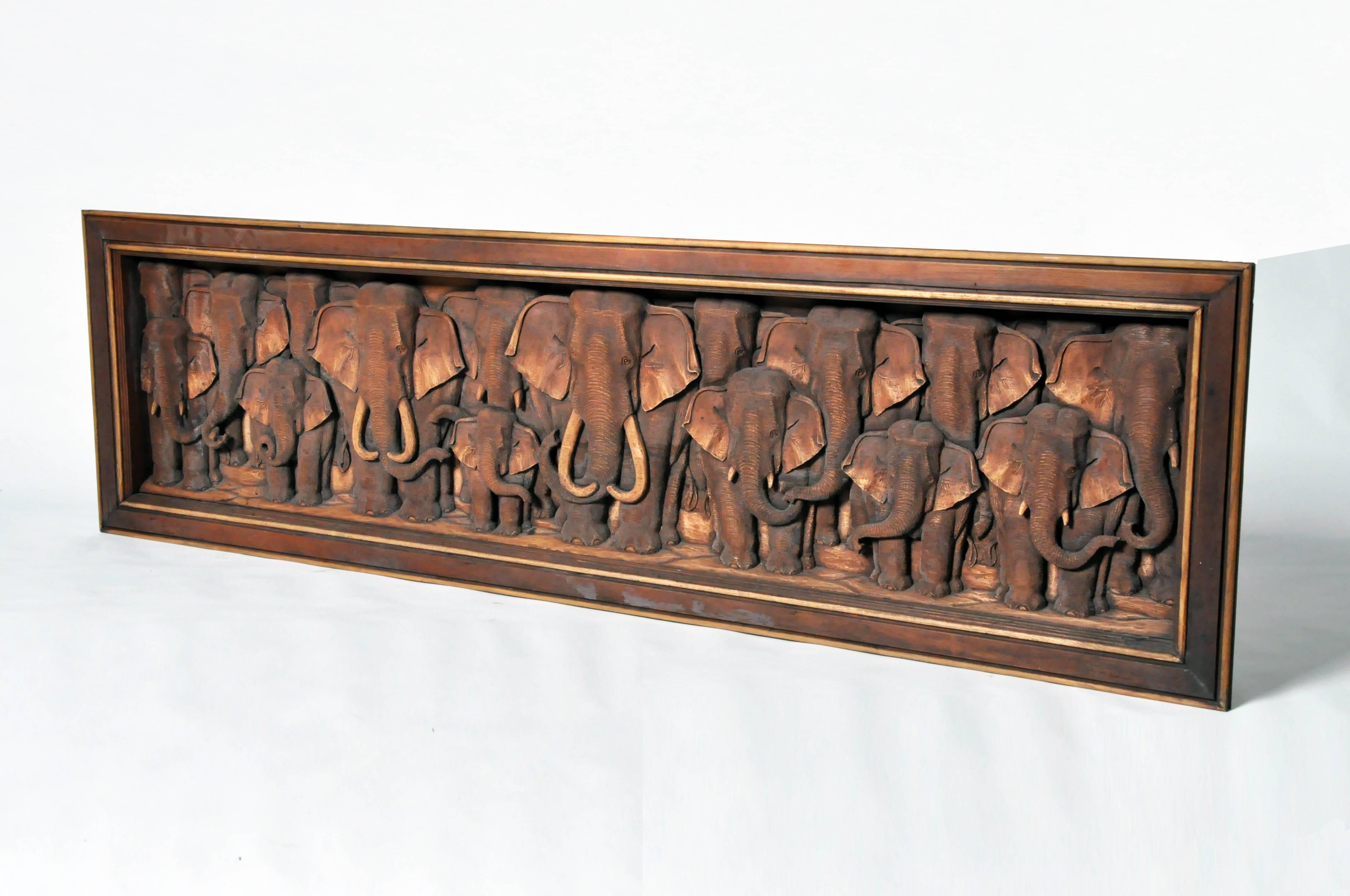 This recently hand-carved wall sculptures depicts a herd of elephants. It is from Thailand and is made from teakwood.