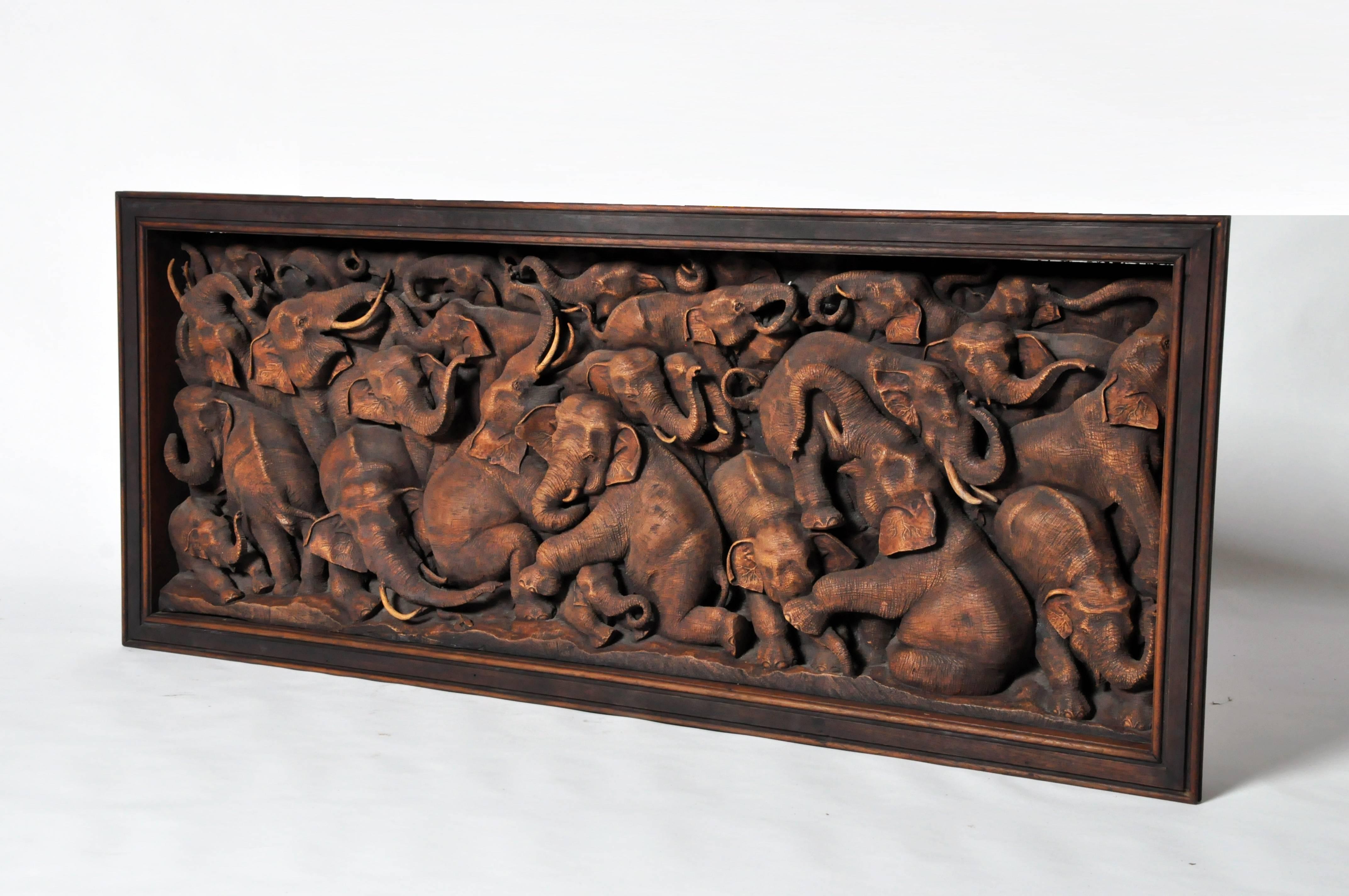This recently hand-carved wall sculptures depicts a herd of elephants of various sizes and positions. It is from Thailand and is made from teakwood.