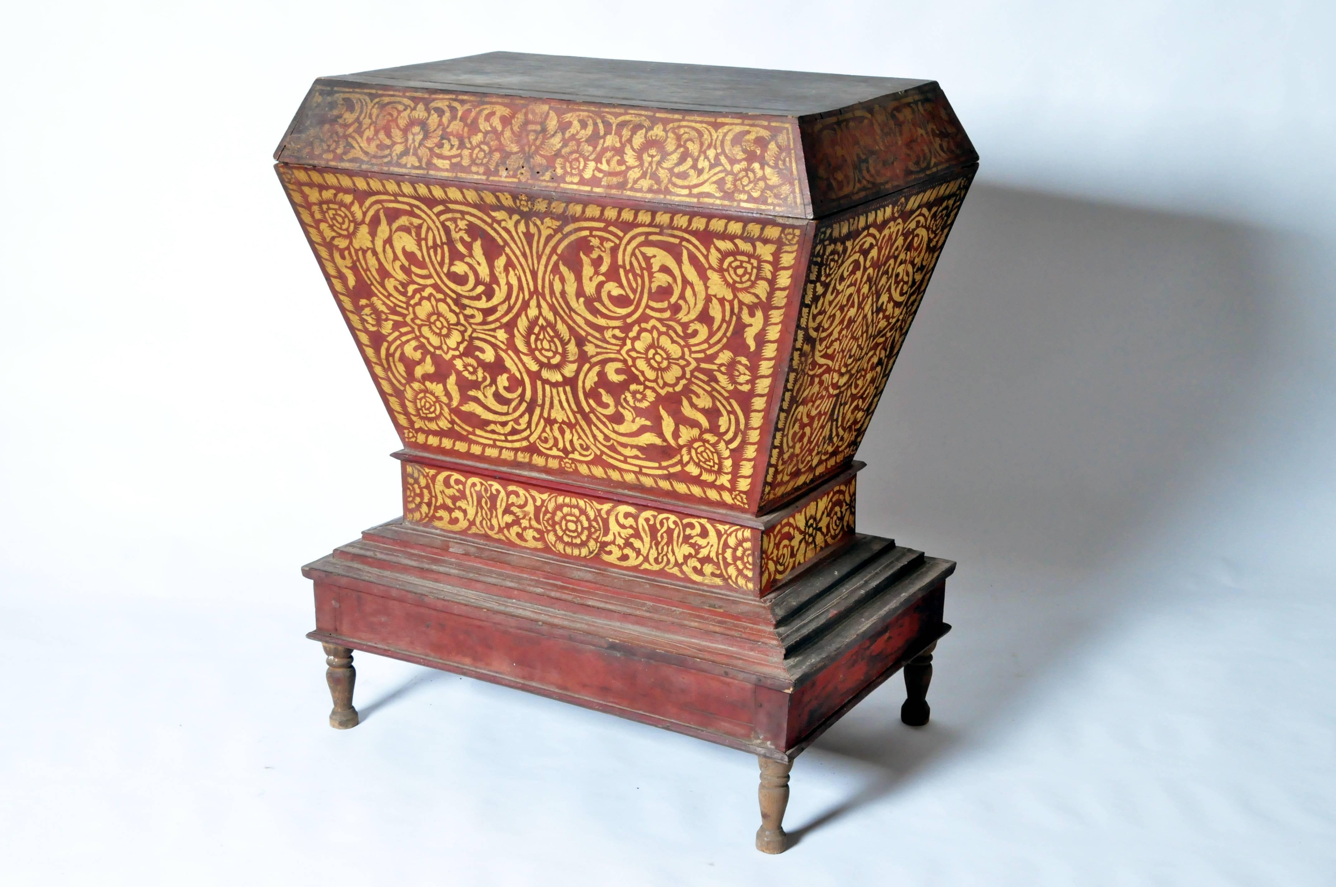 This elegant Lanna Thai manuscript chest features red lacquer with gold motifs. It was made in the early 20th century and has a beautifully aged patina.