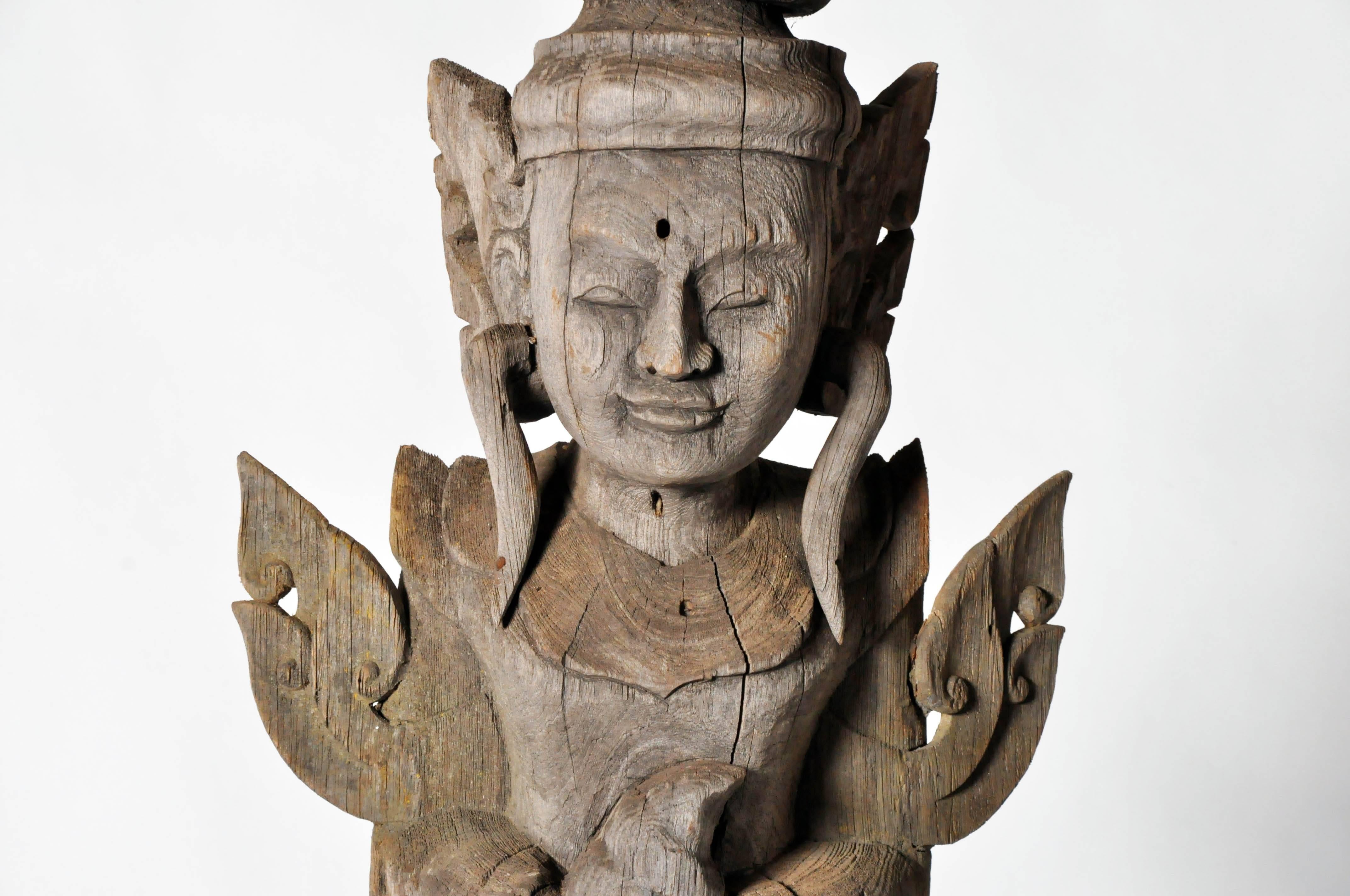 This beautiful greeting angel is from Thailand and is made from teakwood. This type of angel holds its hands clasped together in a respectful wai and wears a heavenly costume decorated with pointed winglets and a draped skirt. According to Therevada