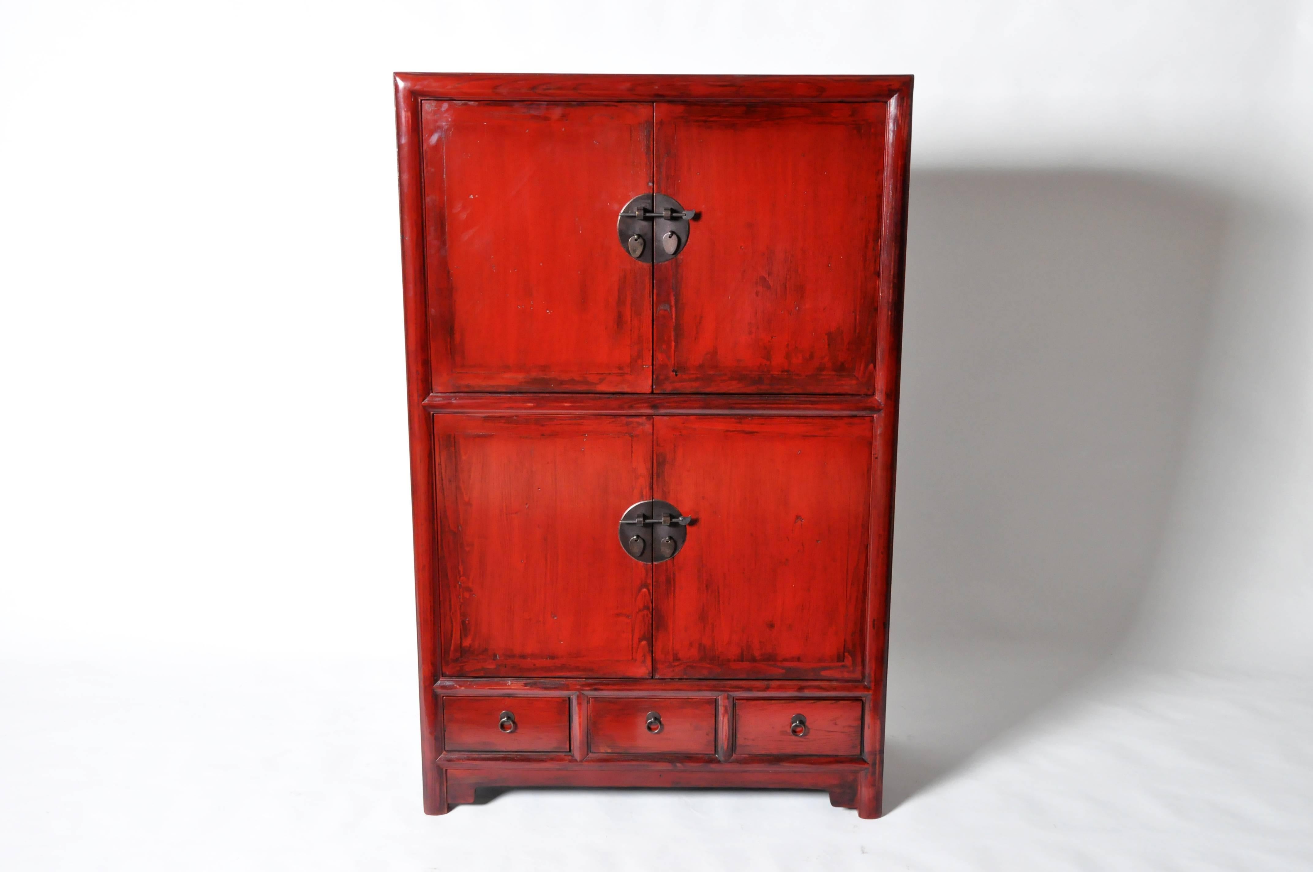 This red lacquered Chinese display cabinet is made from elmwood and has been fully restored. It features two shelves and three drawers for ample storage.