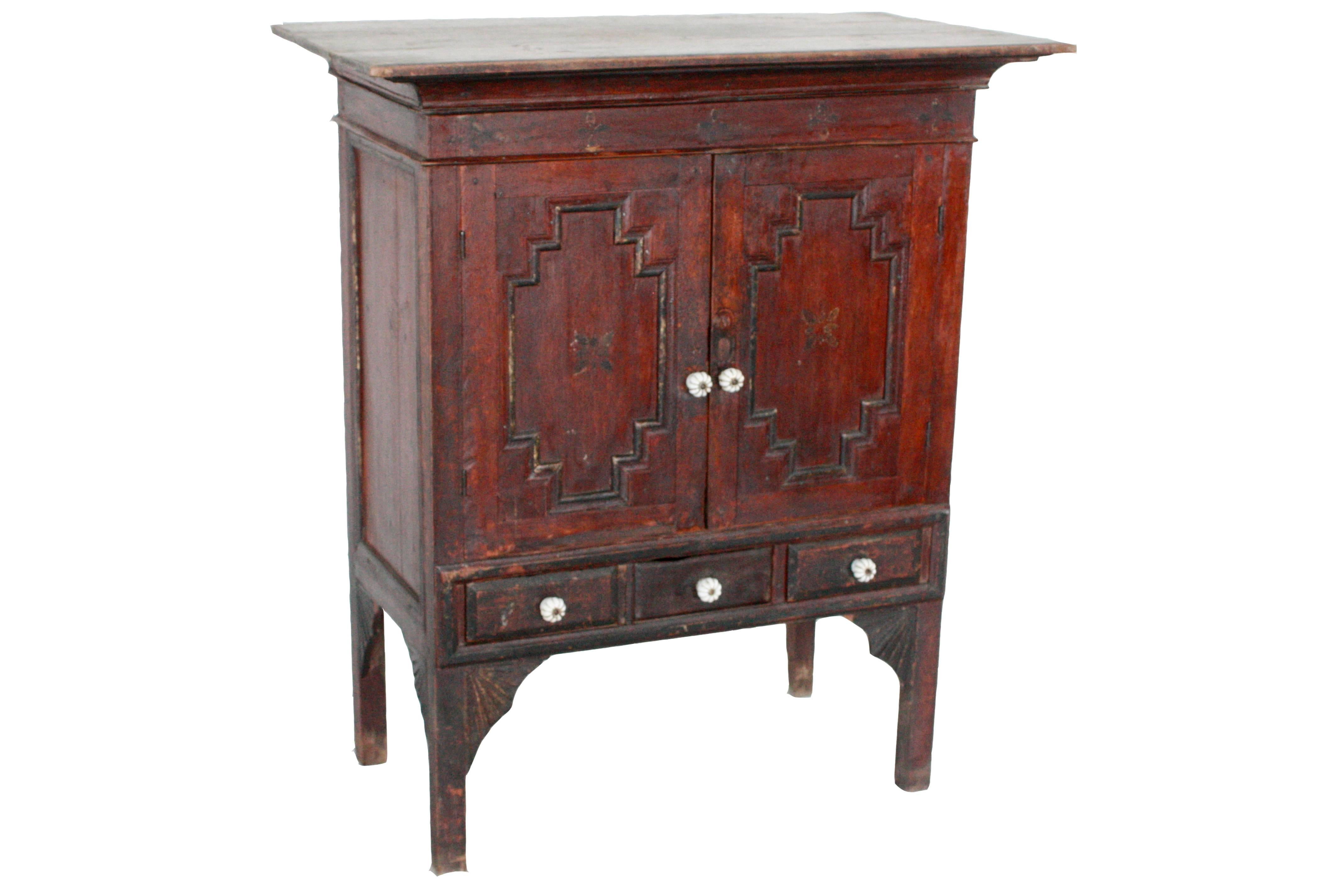 This Southeast Asian side chest is from Myanmar and is made from teakwood. It features a shelf with three drawers for storage.