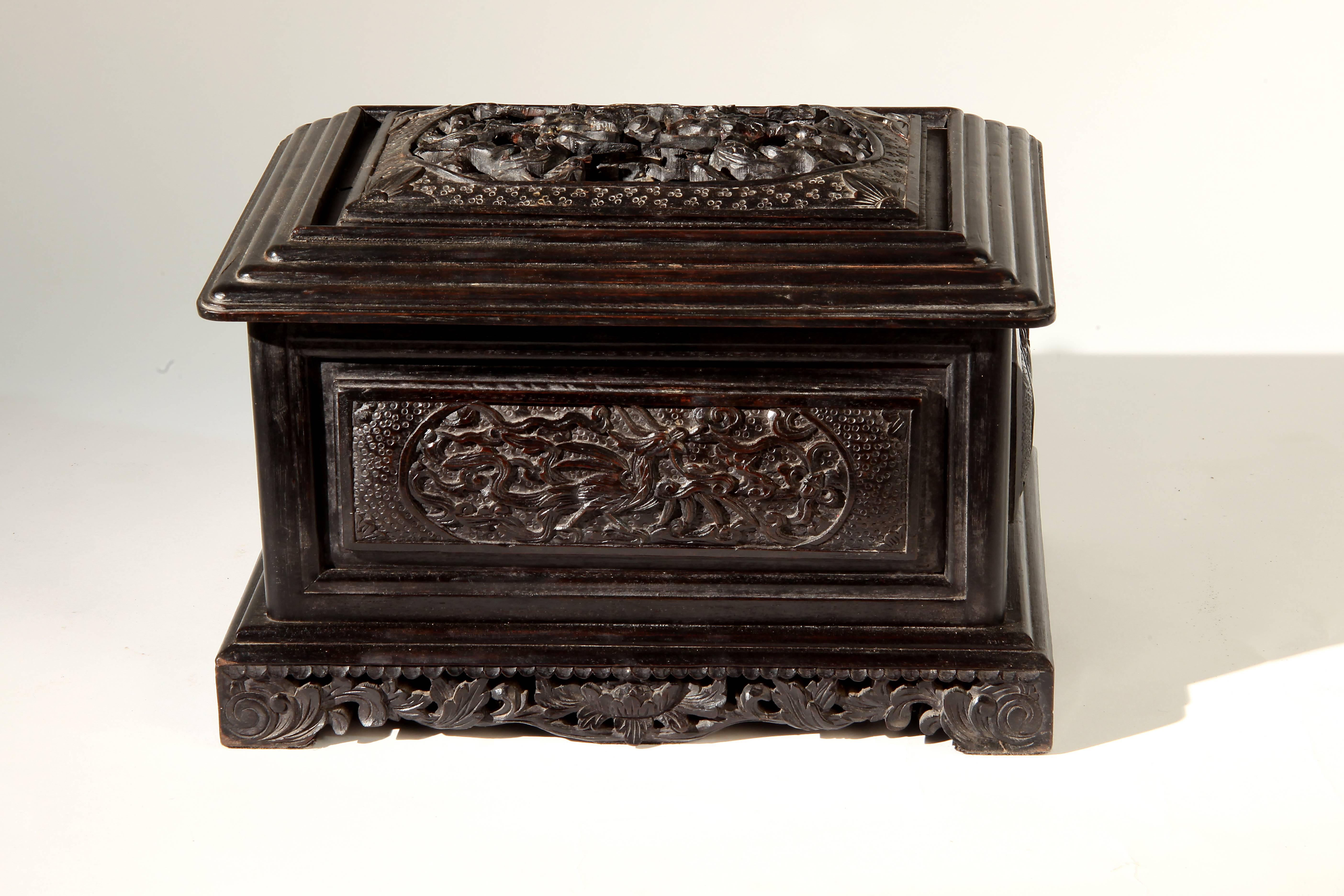This carved jewelry box is from Thailand and is made from teakwood. It features a mirror and storage compartments inside.
