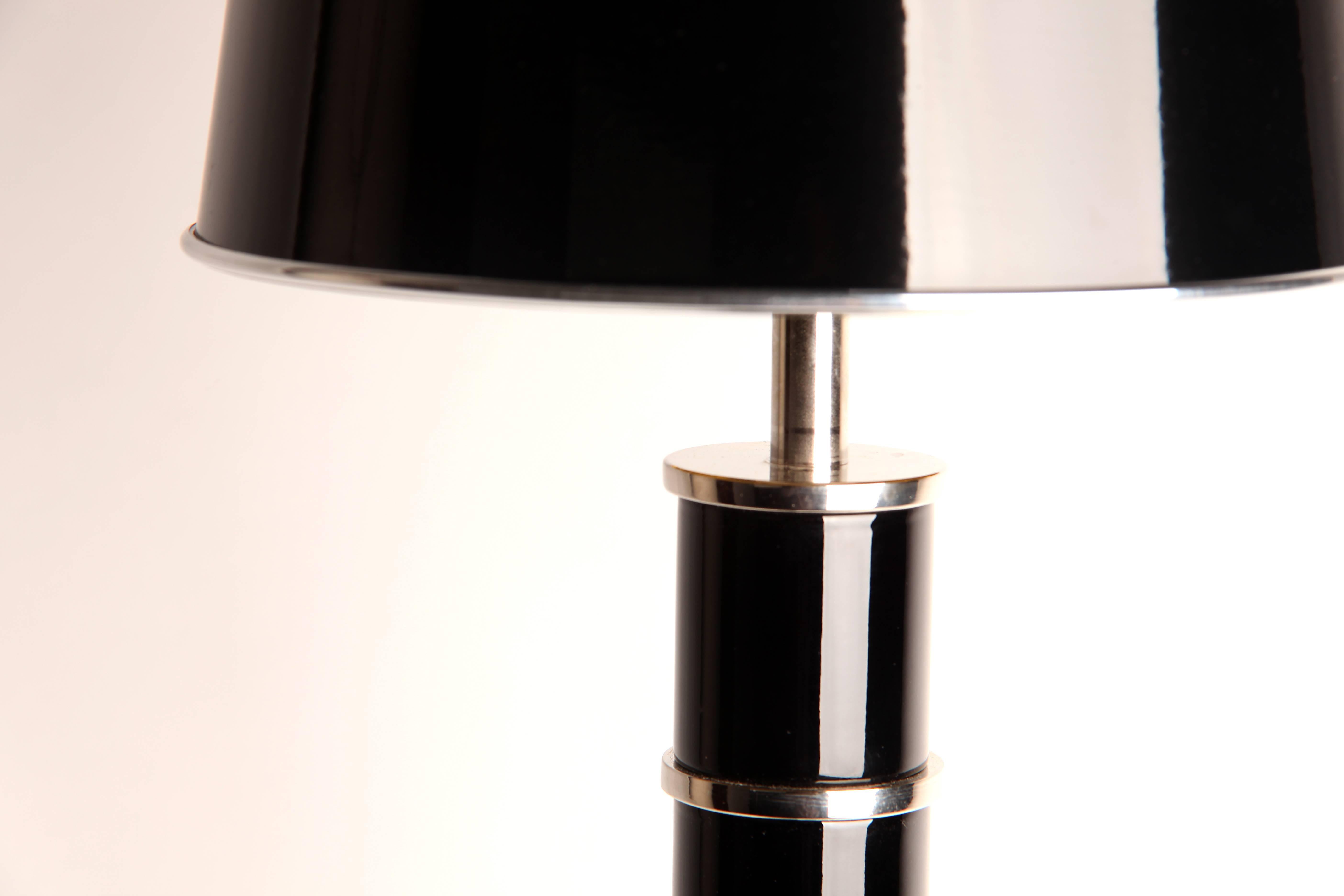 These contemporary lights have cylindrical columns that terminate in circular bases. Chrome accents—which include handsome tripod feet and detailed chrome banding around the top of the piers—add to their masculine presence, making them a sleek