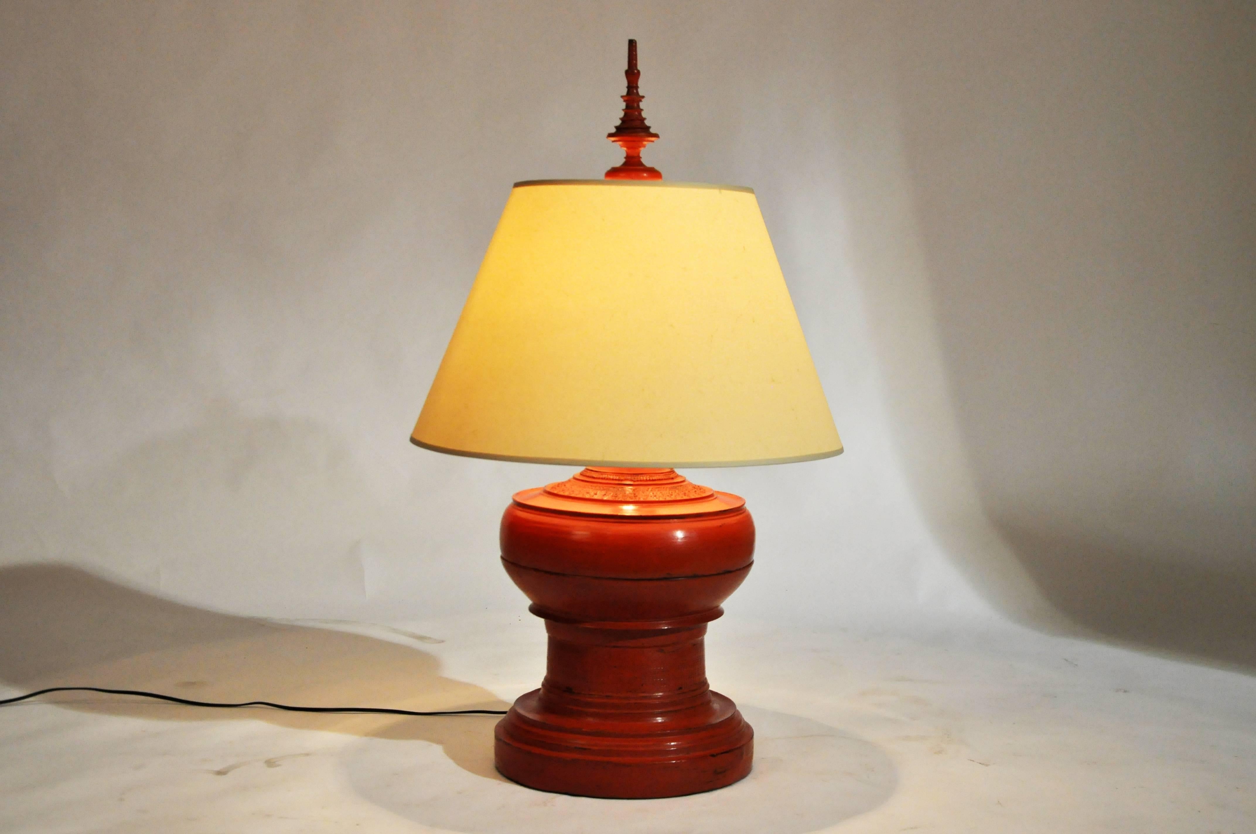 This Thai temple offering urn is from Thailand and was converted to a table lamp wired for use in the U.S. The lamp is made from red lacquer over teak.