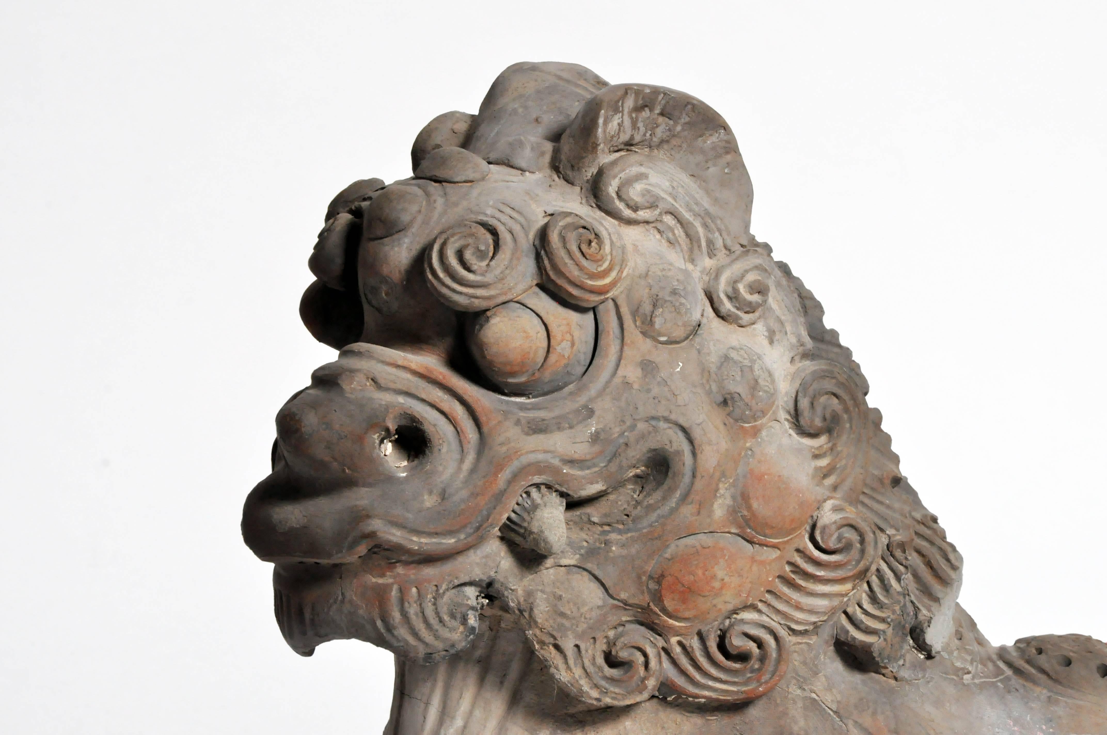 Northern Chinese roofs were made from grey terracotta tiles. The peak of the roof was often decorated with tiles featuring mythological creatures and other protective talismans. This foo dog was placed at the end of a row of decorative figures. The