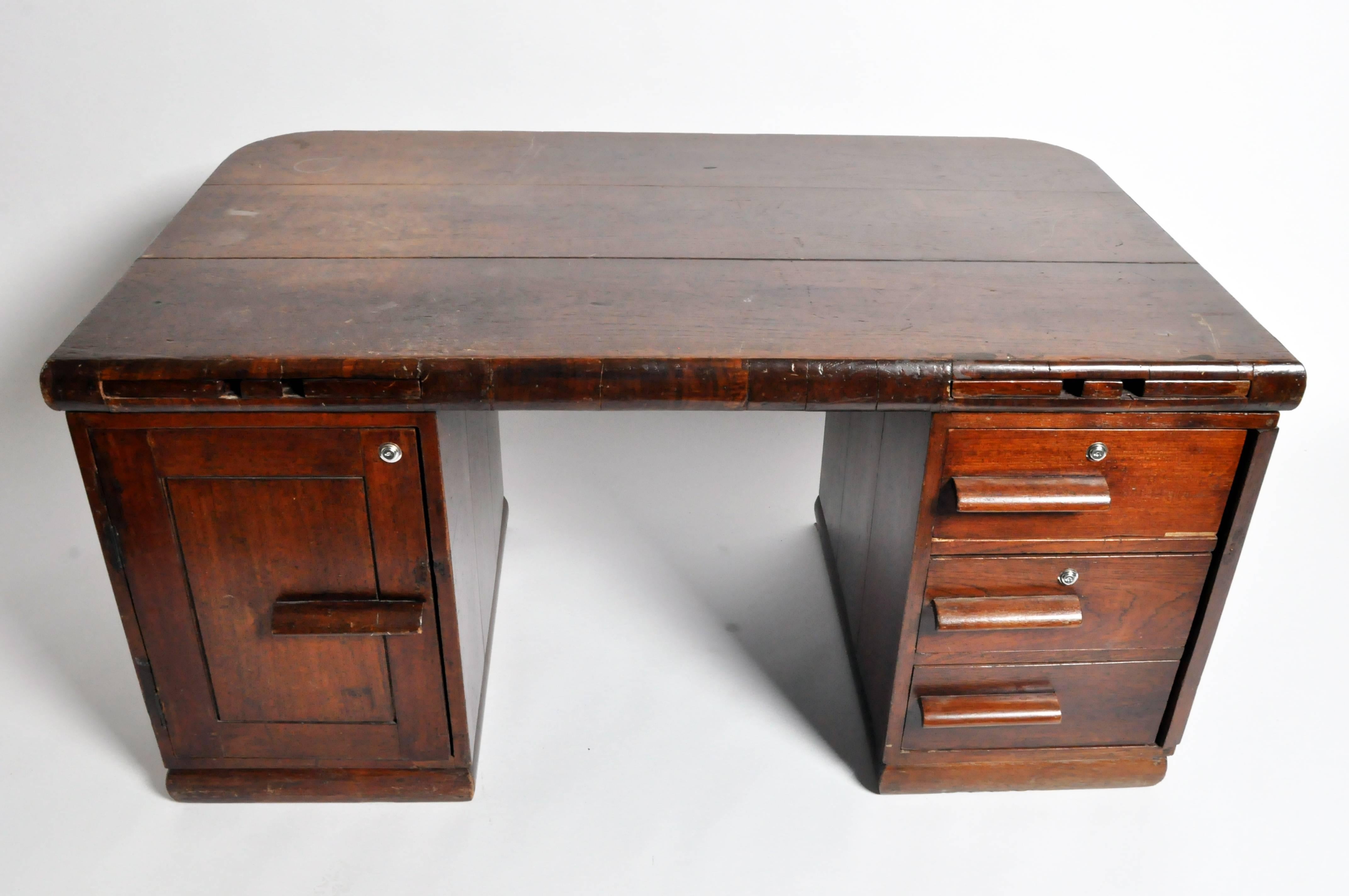 Hailing from Rangoon Burma, this handsome partners desk features a unique combination of British Colonial and Art Deco design elements. Whether used in a home or office space, it lends a smart, vintage beauty.